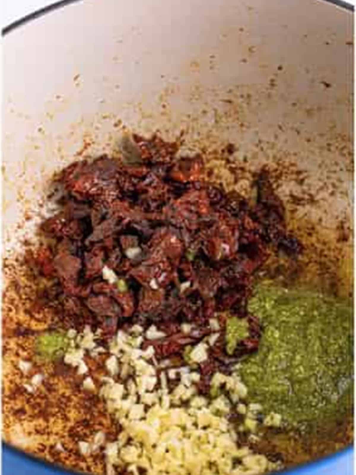 Sundried tomatoes, garlic, and pesto added to the pot.