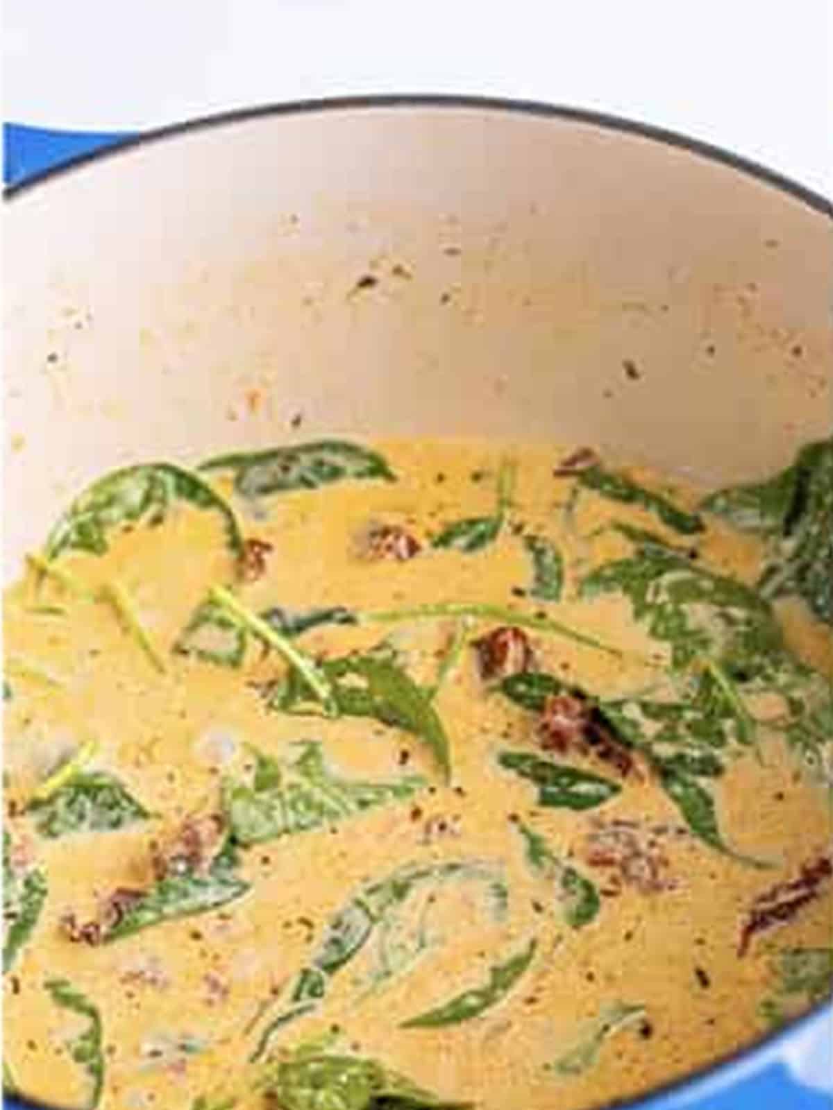 Baby spinach wilting into the creamy sauce.