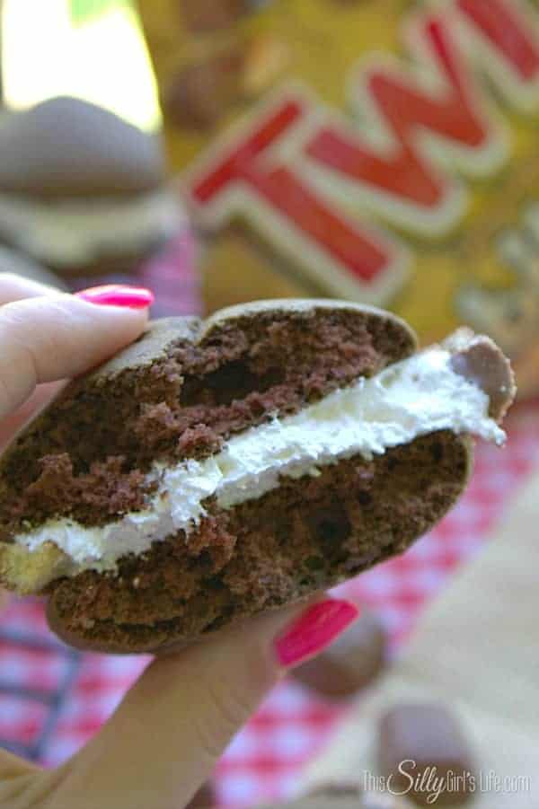 A twix whoopie pie cut in half to show the fluffy marshmallow filling and Twix pieces.