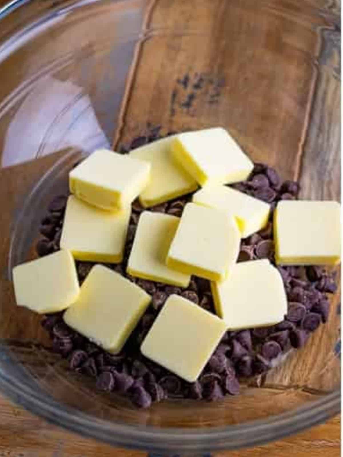 Butter cubes and semi-sweet chocolate chips in a glass bowl ready to melt for two bite brownies.