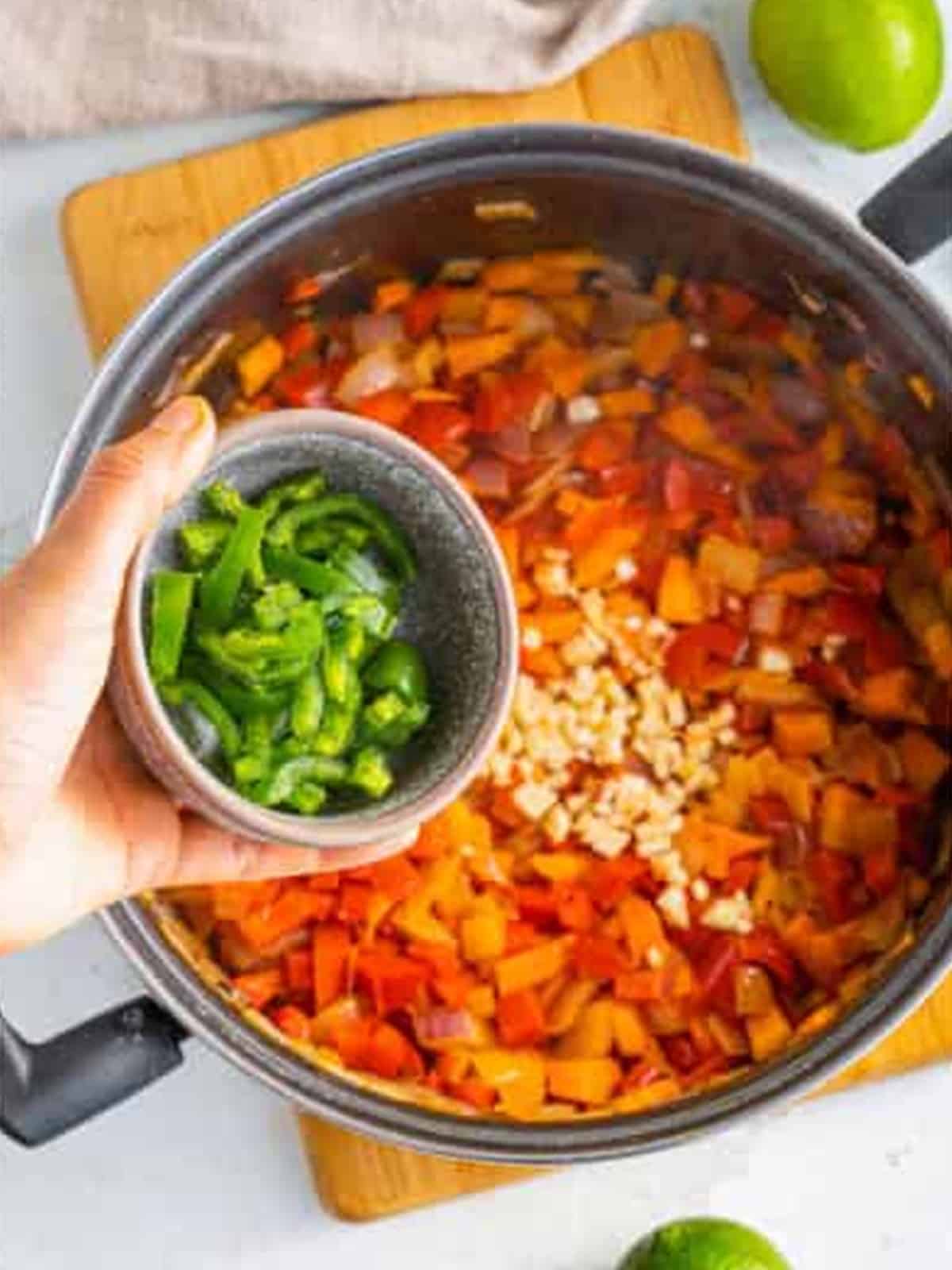 Diced carrots sauteing in olive oil in a large pot.