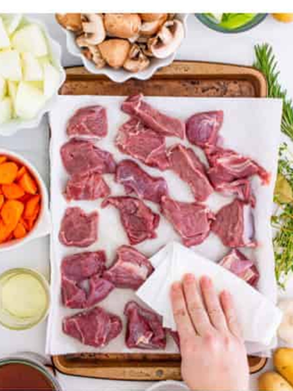 Venison stew meat rinsed and patted dry on a paper towel lined tray.