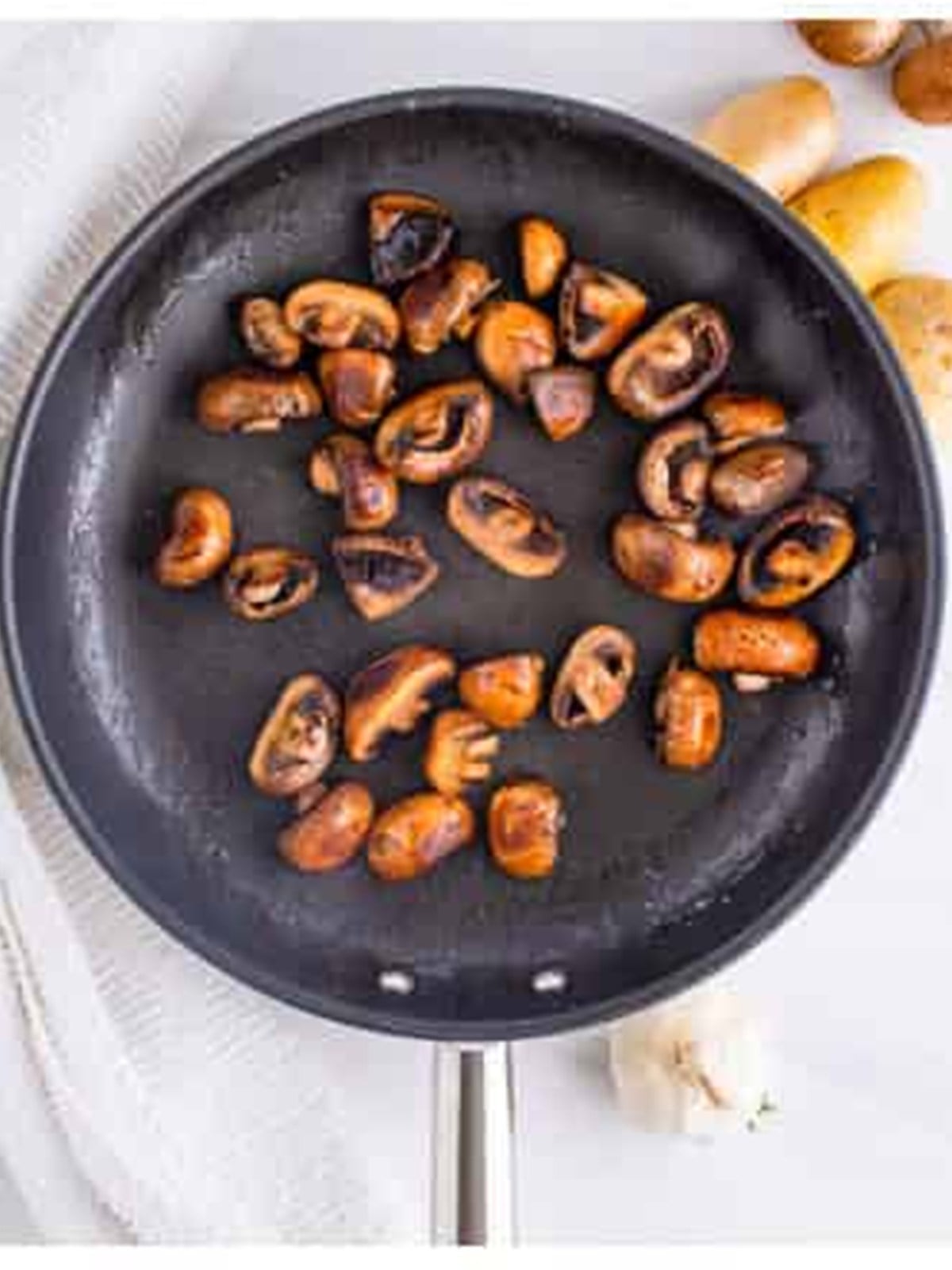 Baby bella mushrooms charred in a skillet for venison stew.