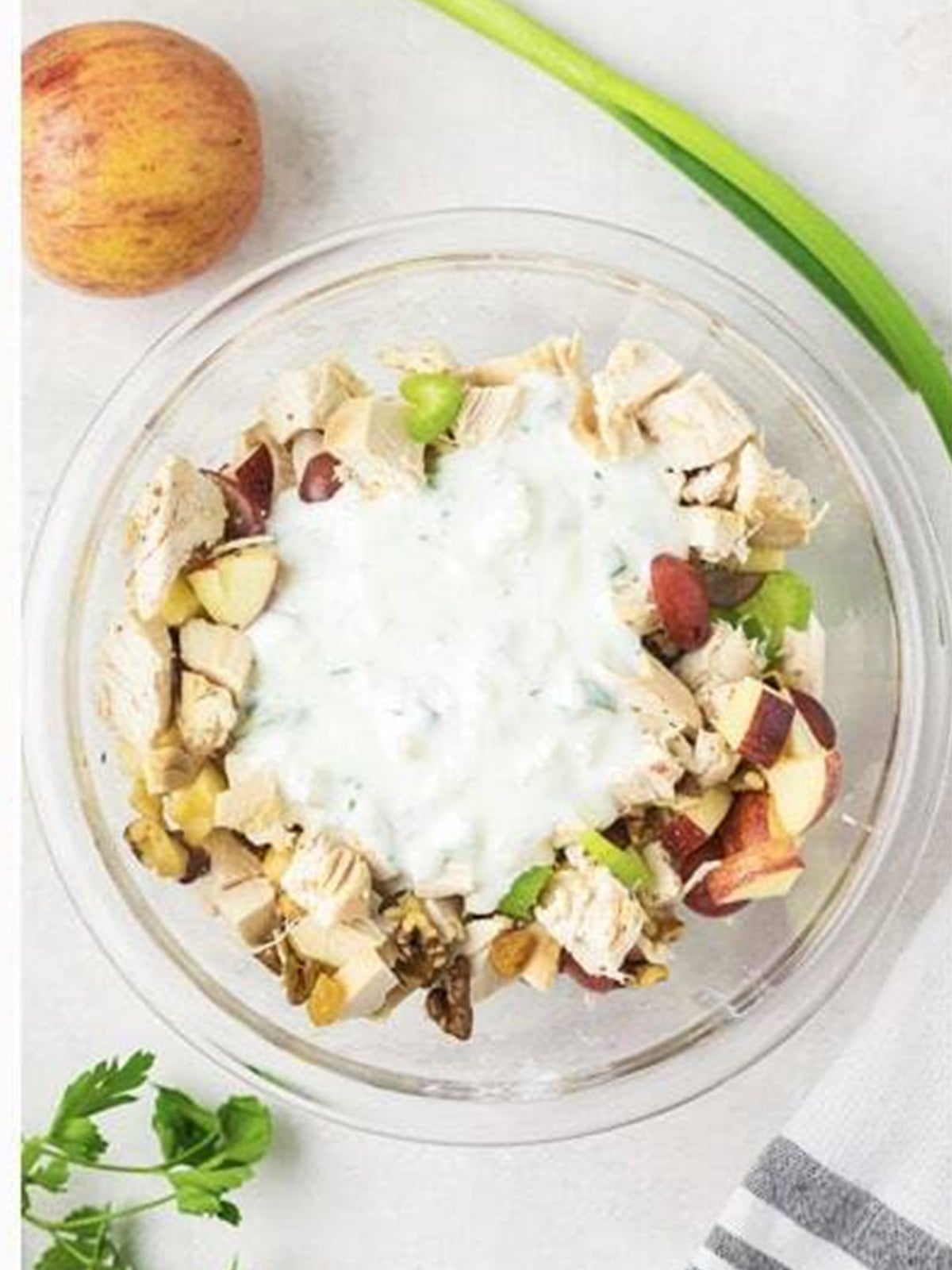 Creamy pineapple yogurt dressing poured over the waldorf chicken salad ingredients.