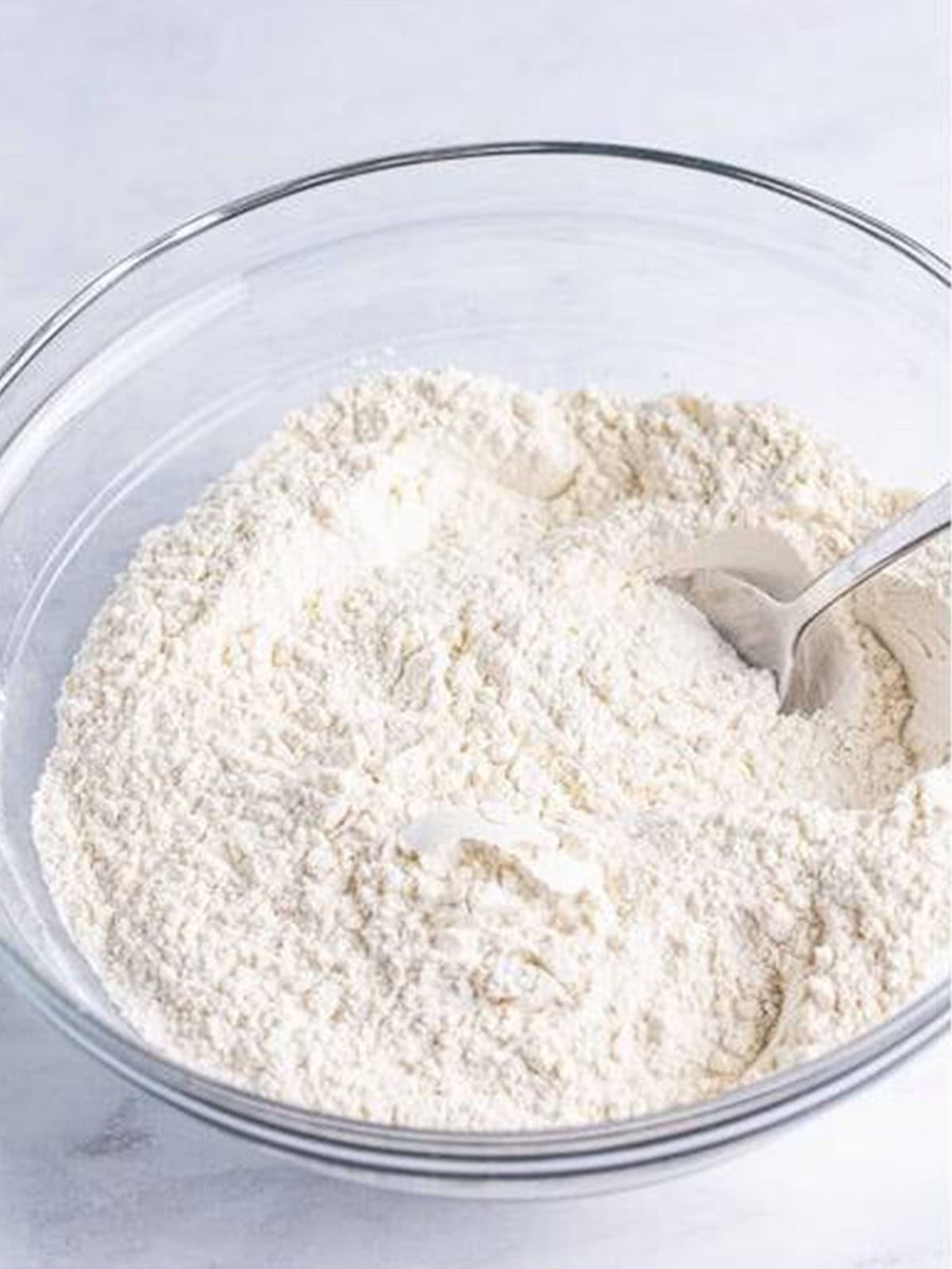 Flour, baking powder, and salt whisked in a bowl for wedding cake cupcakes.