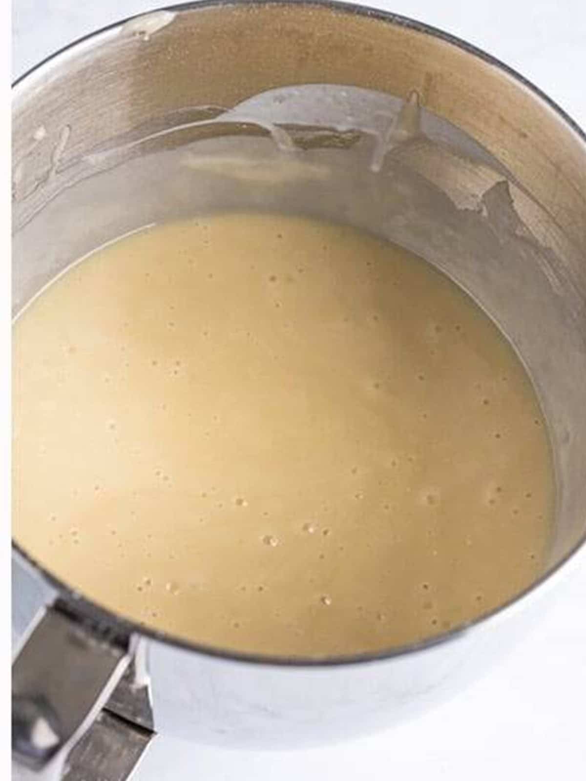 Smooth white wedding cake cupcake batter in a mixing bowl.
