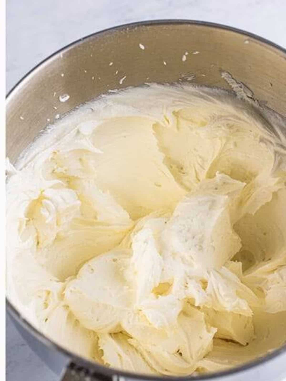 Whipped almond buttercream frosting in a bowl for wedding cake cupcakes.