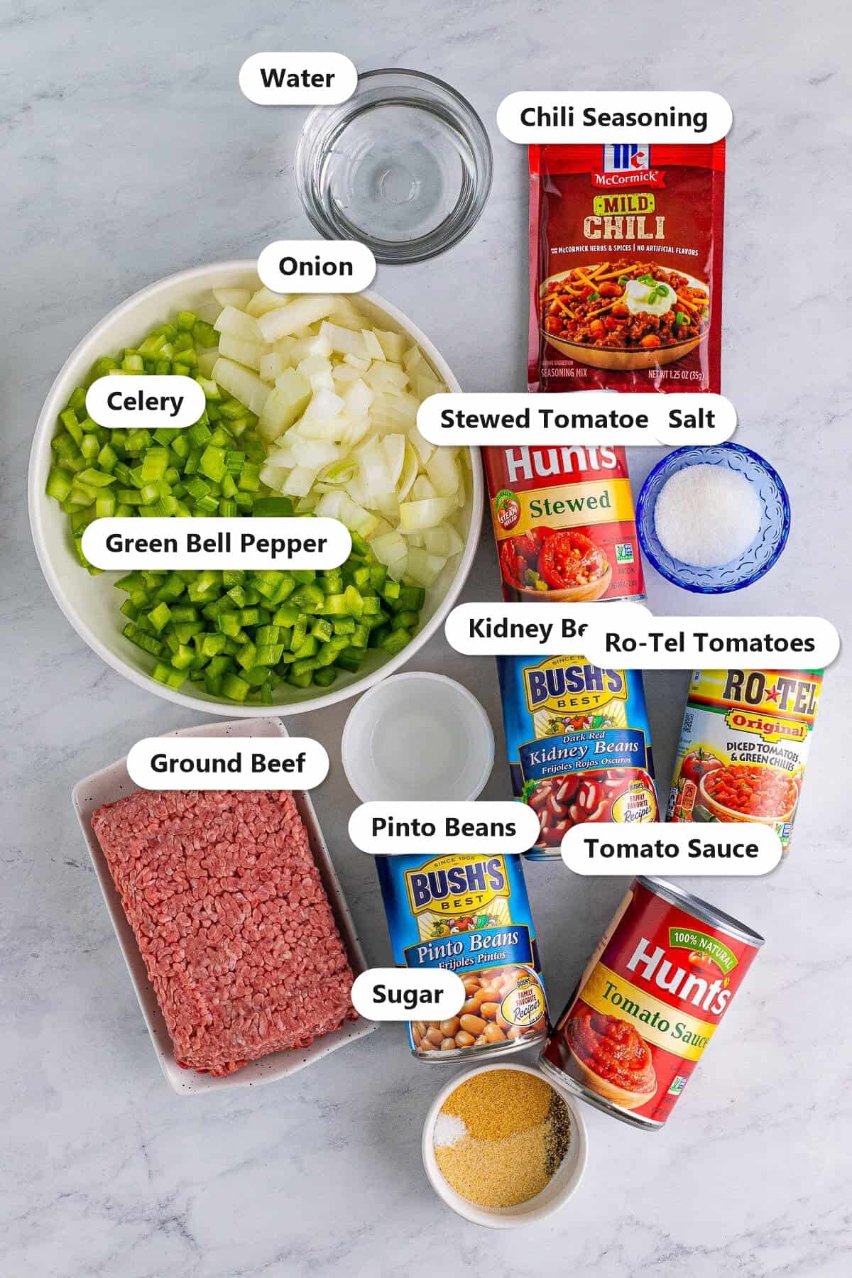 Labeled ingredients for Wendys chili including ground beef, celery, onion, green bell pepper, chili seasoning, kidney beans, pinto beans, tomato sauce, stewed tomatoes, Ro-Tel diced tomatoes, sugar, salt, and water.
