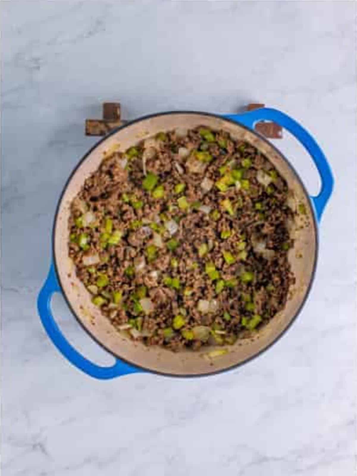 Diced celery, onion, and green bell pepper added to the browned ground beef.