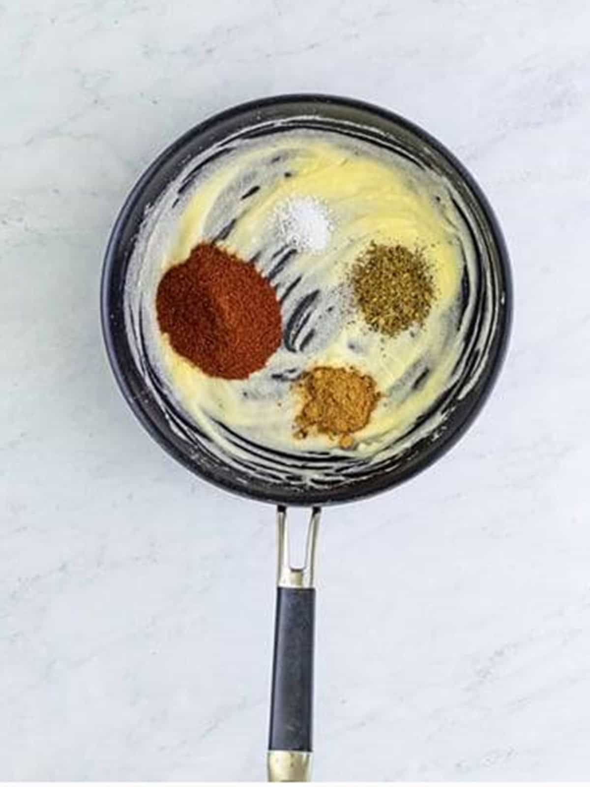 Chili powder, cumin, oregano, and salt added to the roux for wet burrito red sauce.