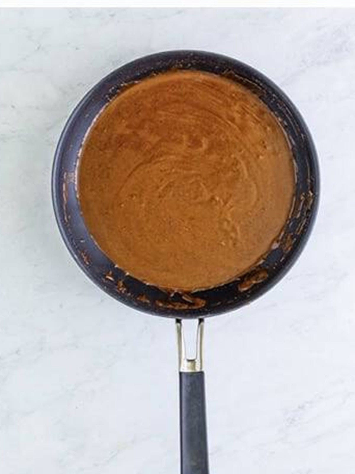 Chicken stock whisked into the spiced roux until smooth and dark.