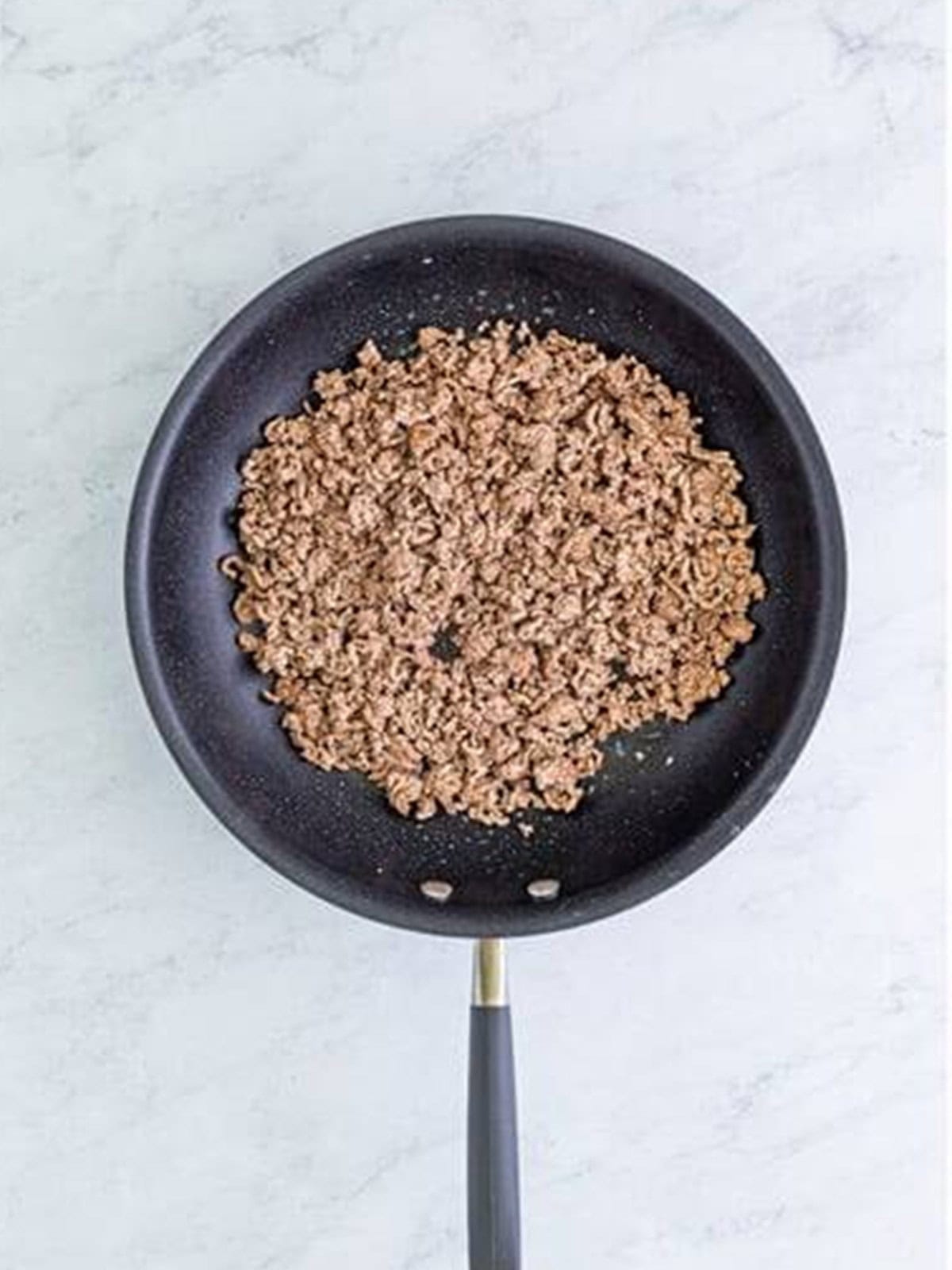 Ground beef browned and crumbled in a large skillet.