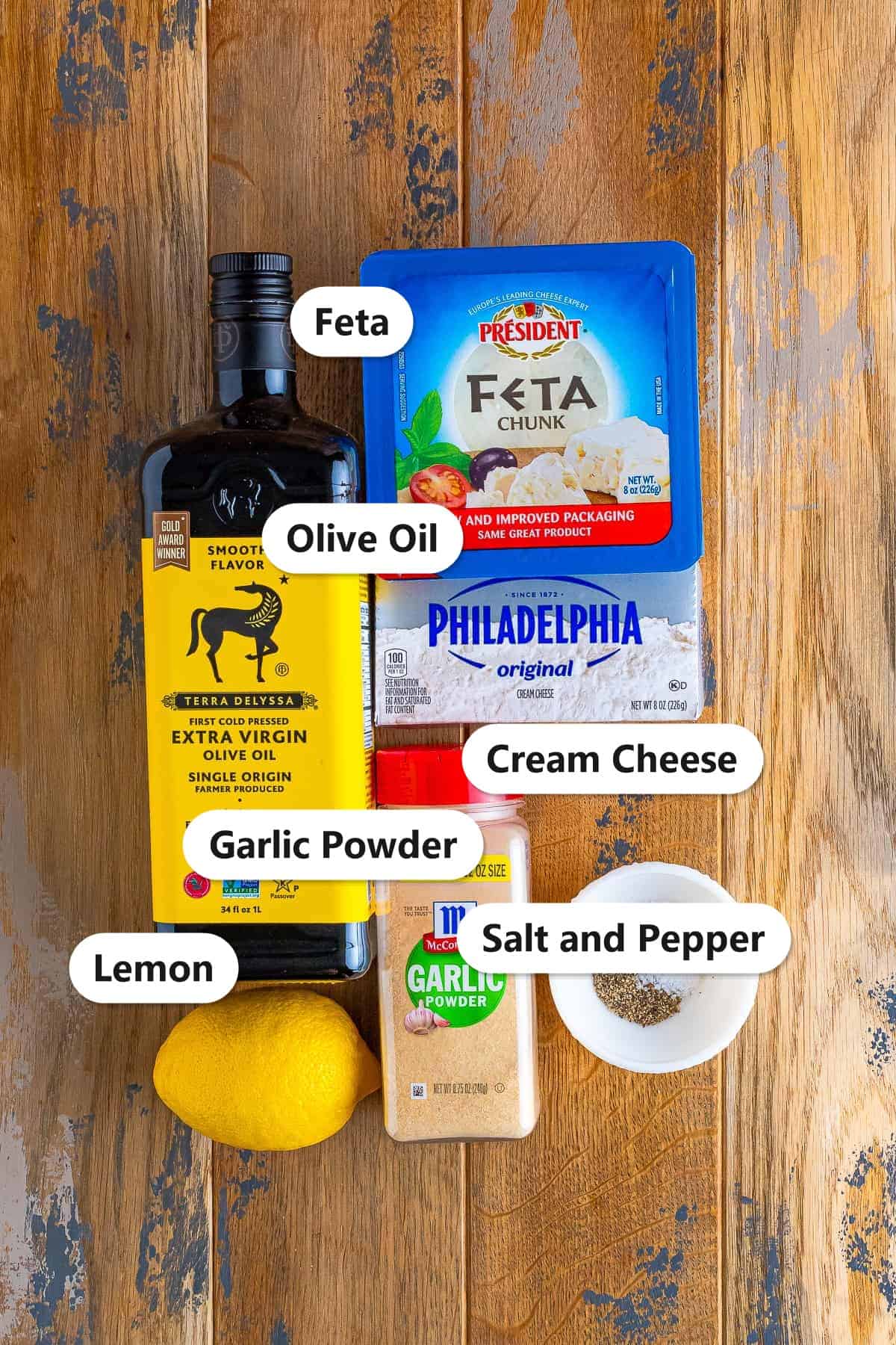 Labeled ingredients for Whipped Feta including feta, cream cheese, olive oil, garlic powder, lemon, salt and pepper.