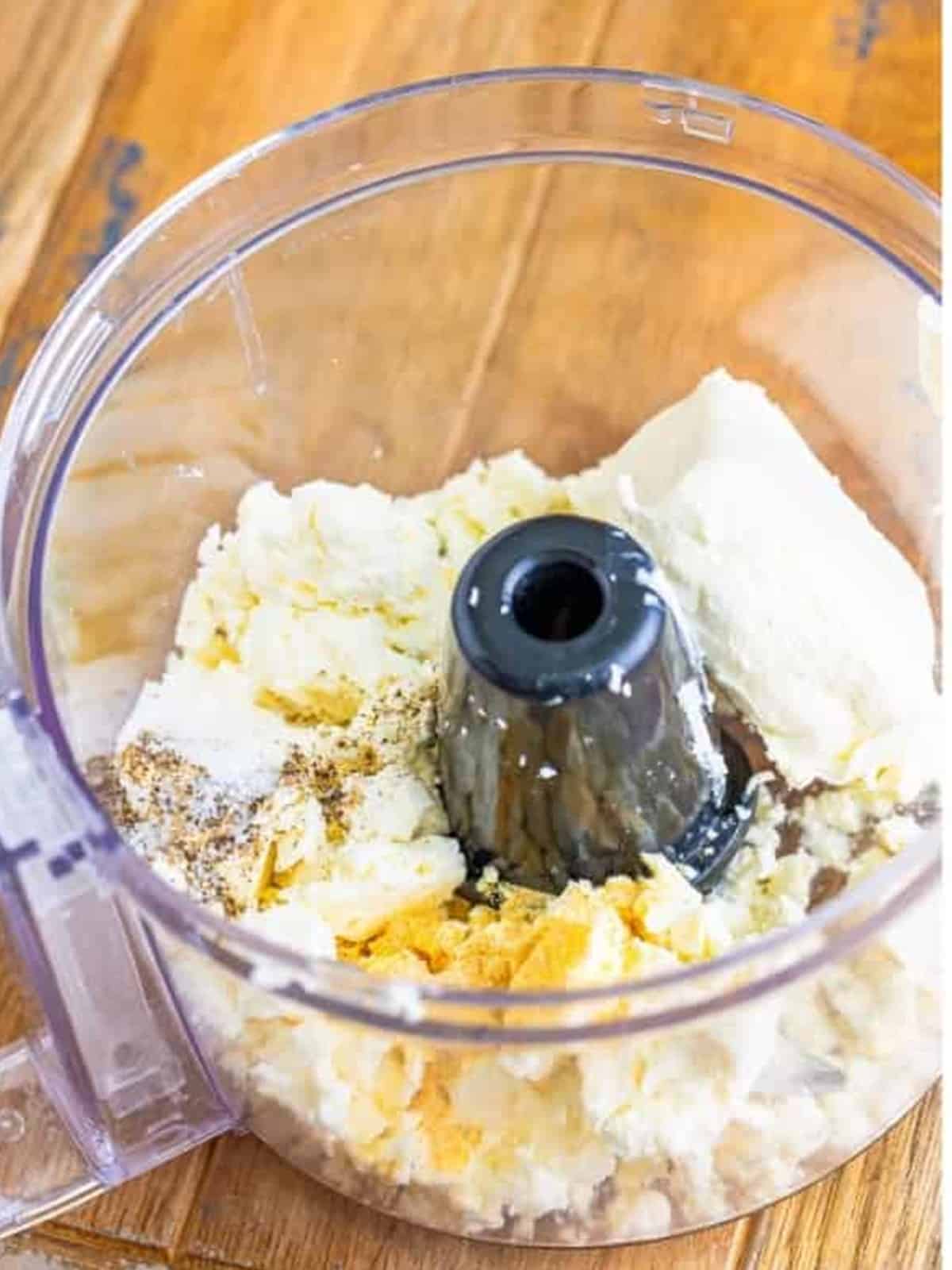 Feta, cream cheese, garlic powder, salt, and pepper in a food processor for Whipped Feta Dip.