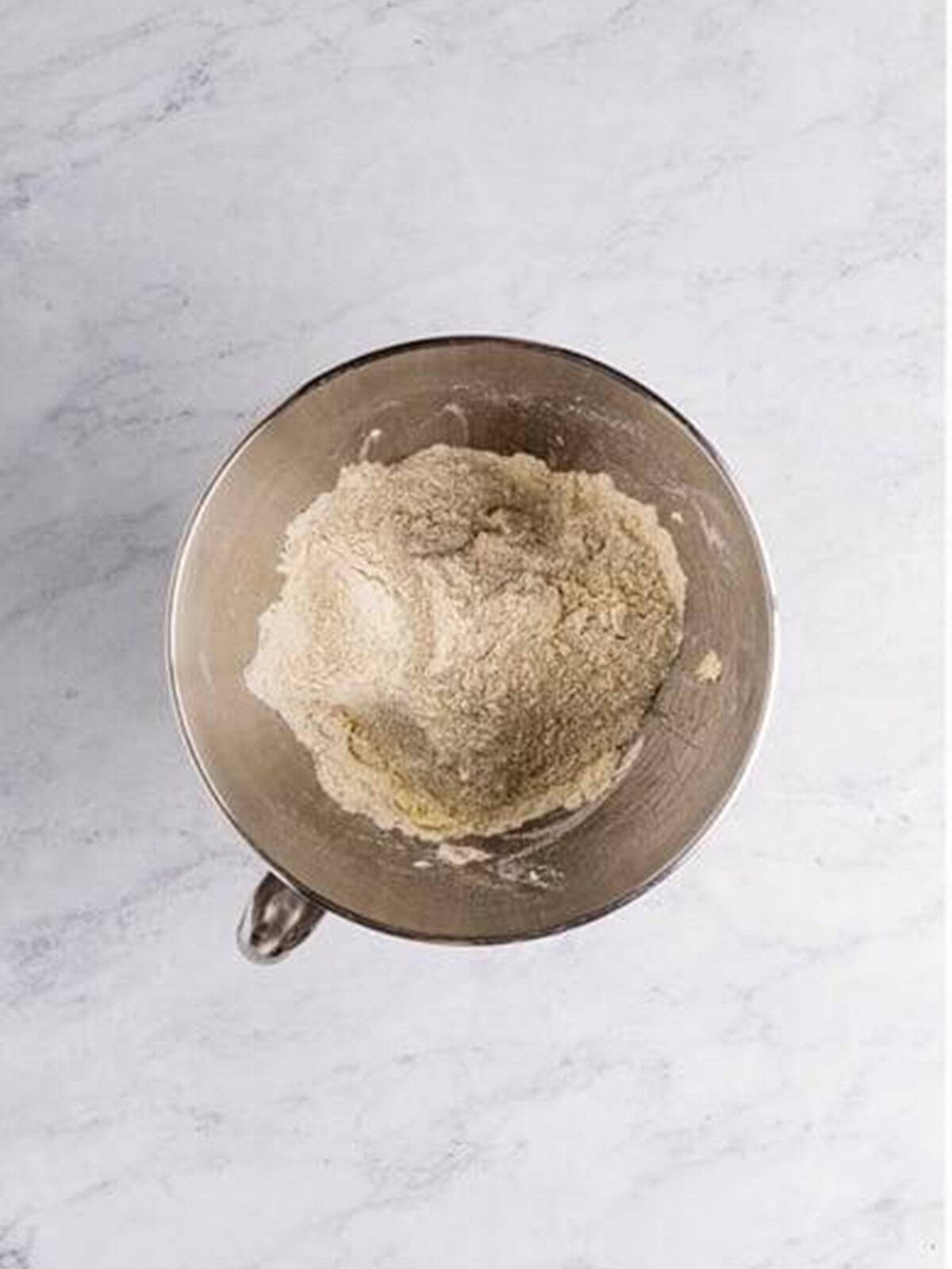 Flour, dry milk, sugar, yeast, and salt combined in a bowl for white bread dough.