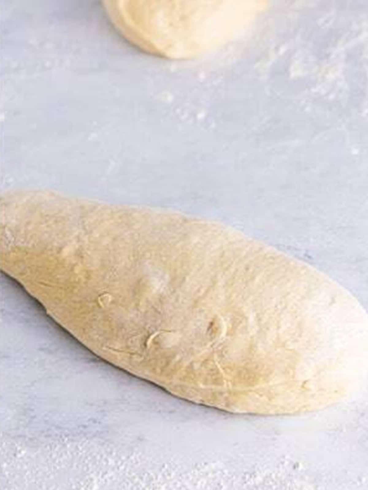 White bread dough rolled into a log to shape the loaf.