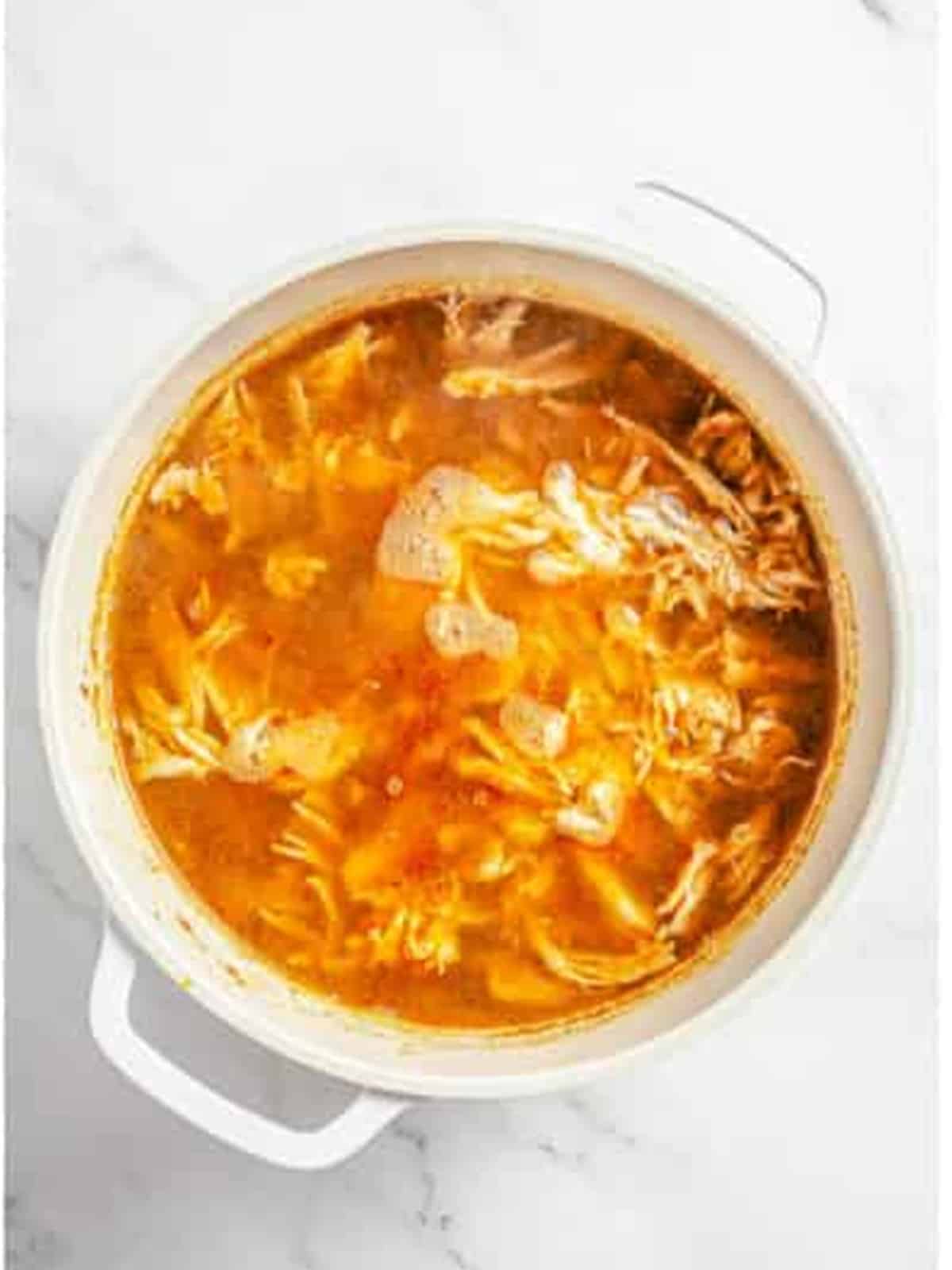 Shredded chicken added back into the pot of white chicken chili.