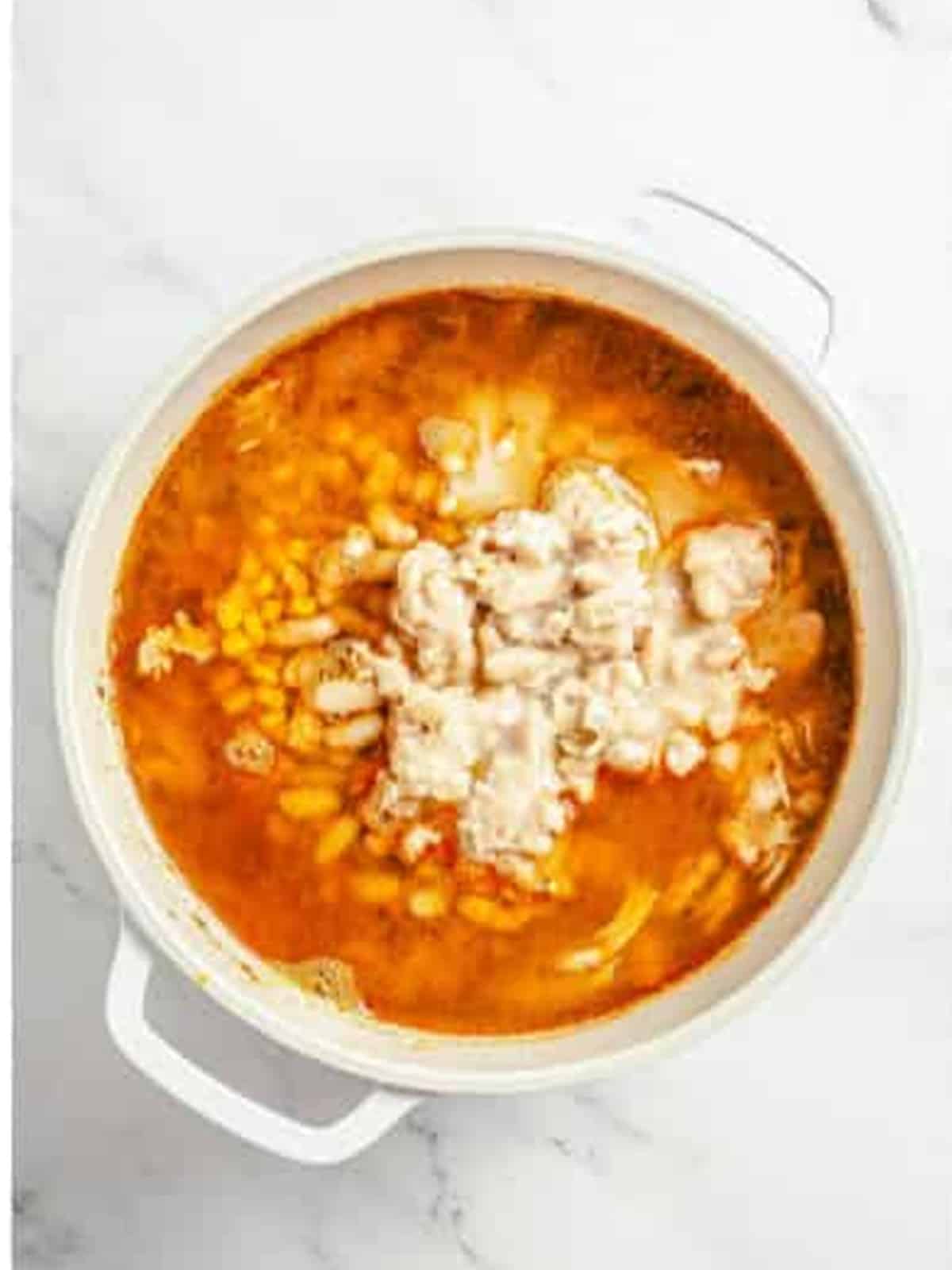 Corn and white beans added to the white chicken chili pot.