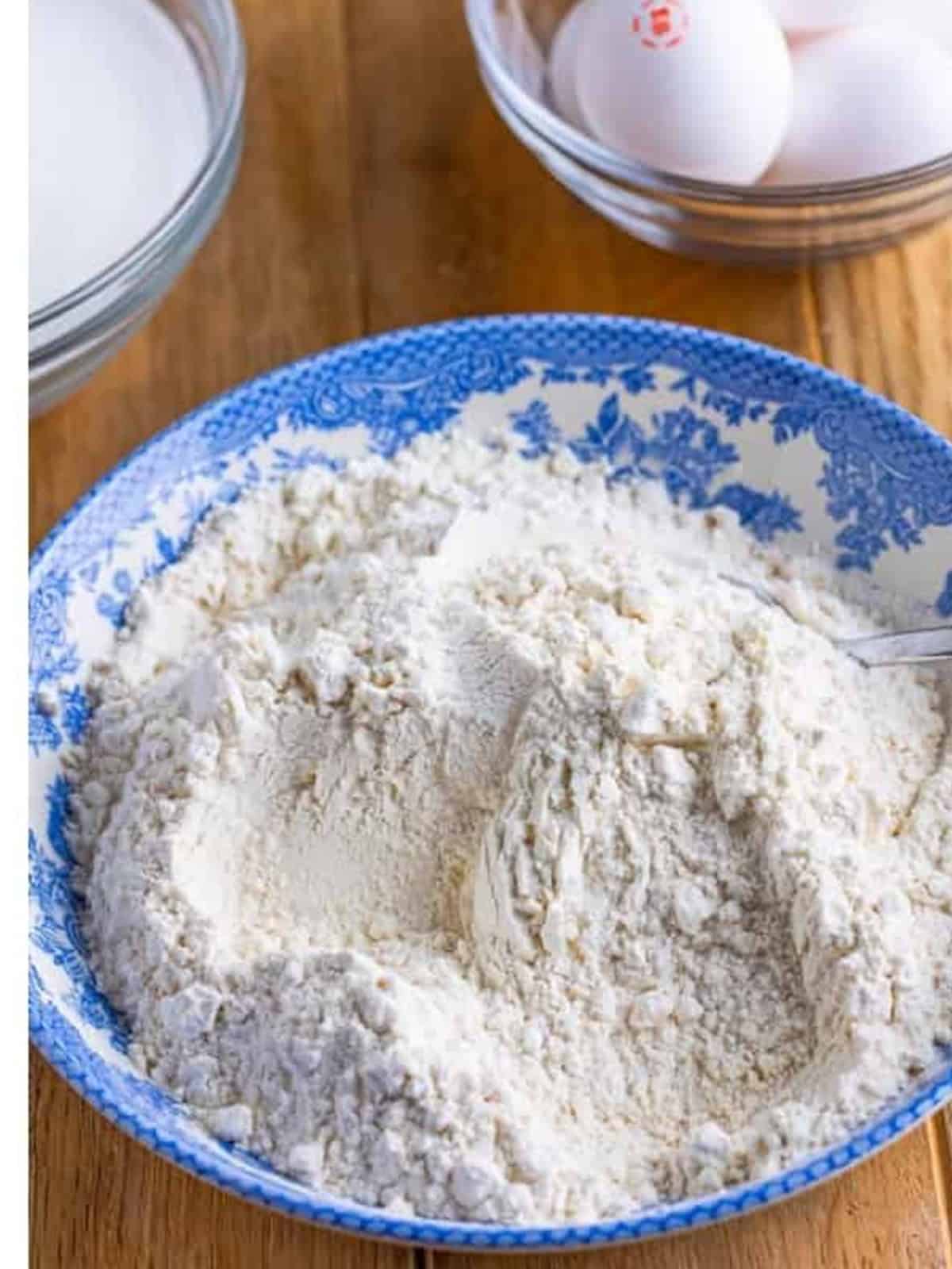 Flour, white chocolate powder, and baking powder whisked together on a plate.