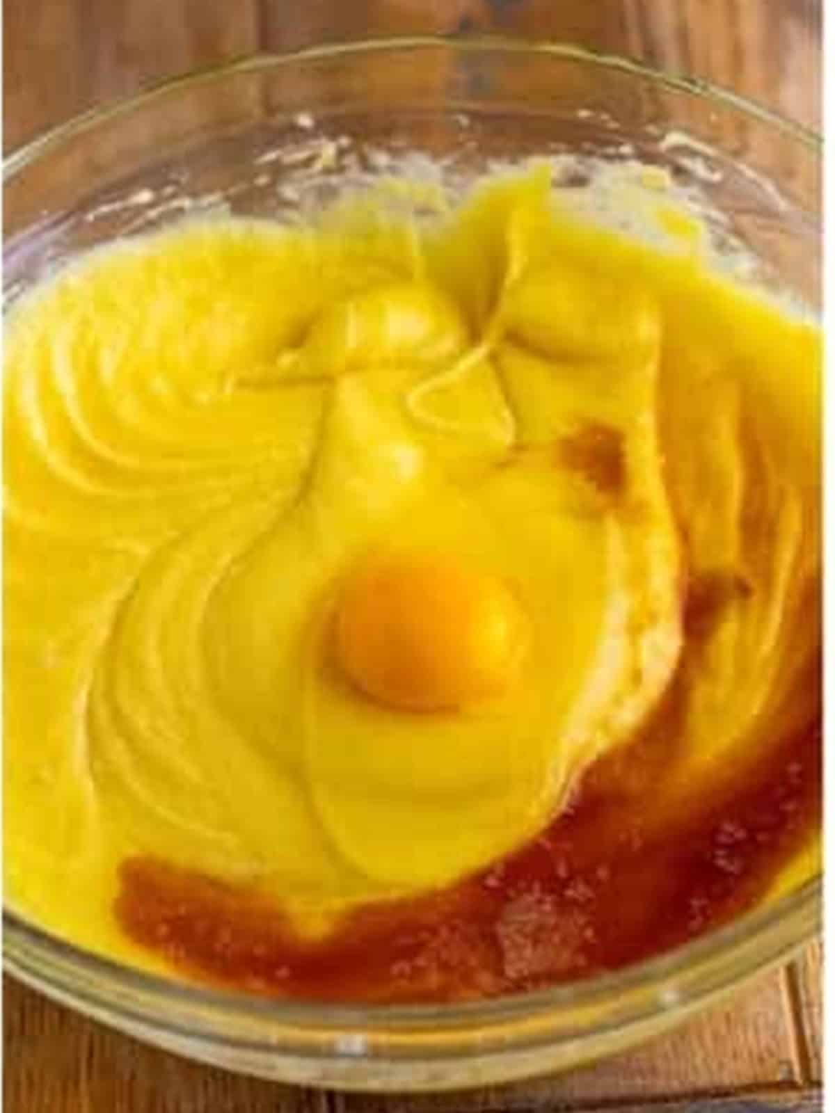 Eggs being added to the melted white chocolate and sugar batter.