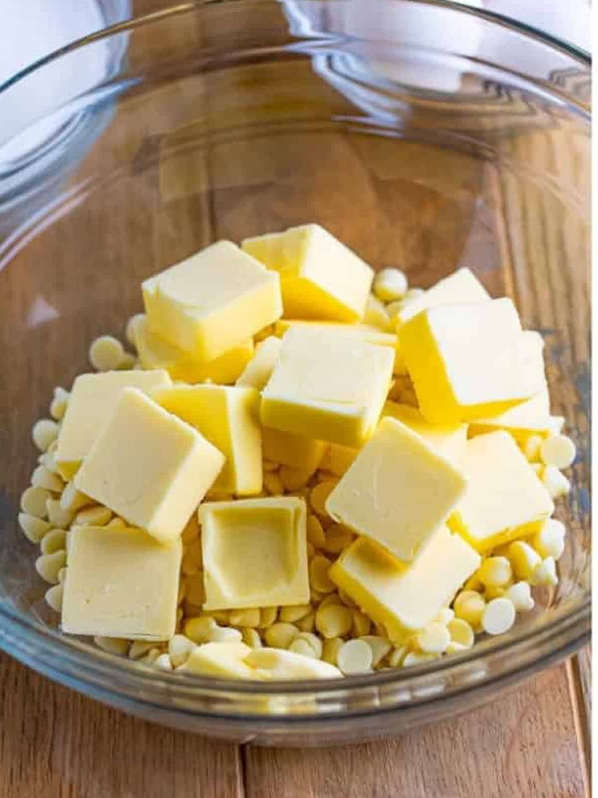 Butter cubes and white chocolate chips in a glass bowl ready to melt for white chocolate brownies.