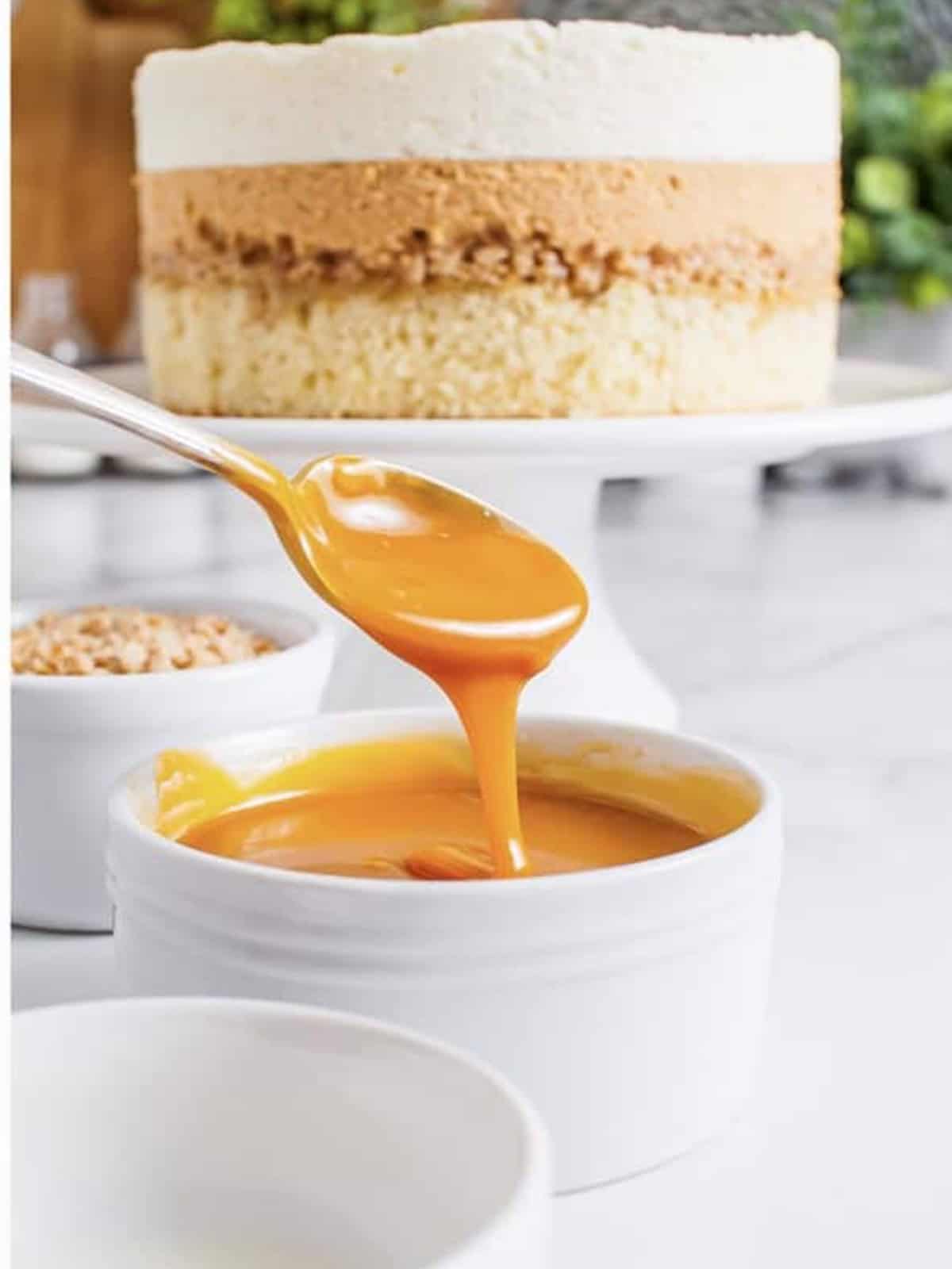 Layered white chocolate mousse cake with cake, butterscotch mousse, and white chocolate mousse.