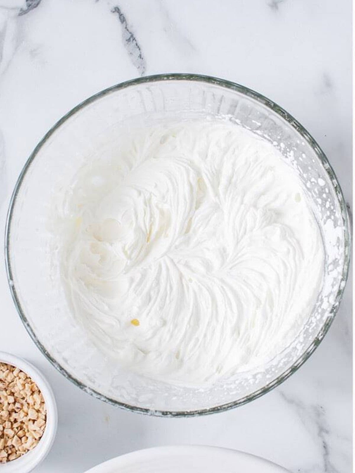Whipped cream being beaten for topping the mousse cake.
