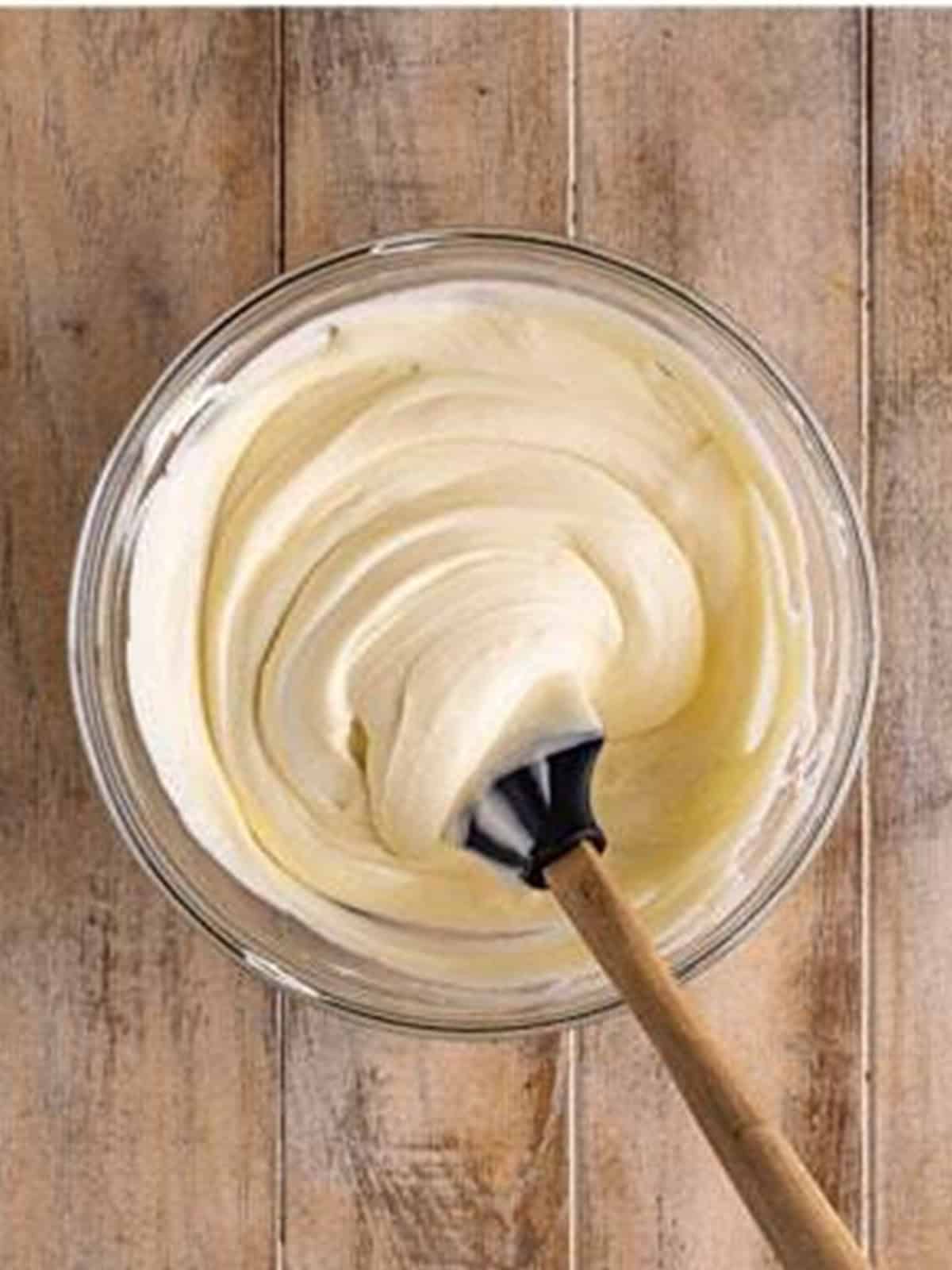 Smooth folded white chocolate mousse in a glass bowl.