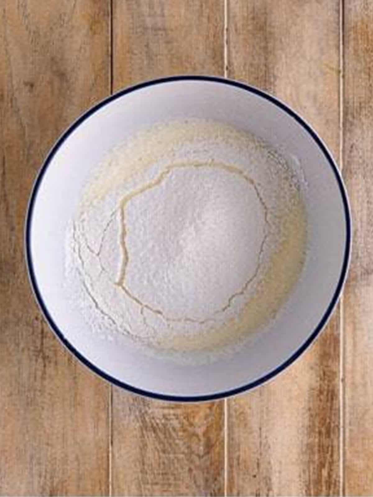 Heavy cream and powdered sugar in a bowl for whipping into white chocolate mousse.