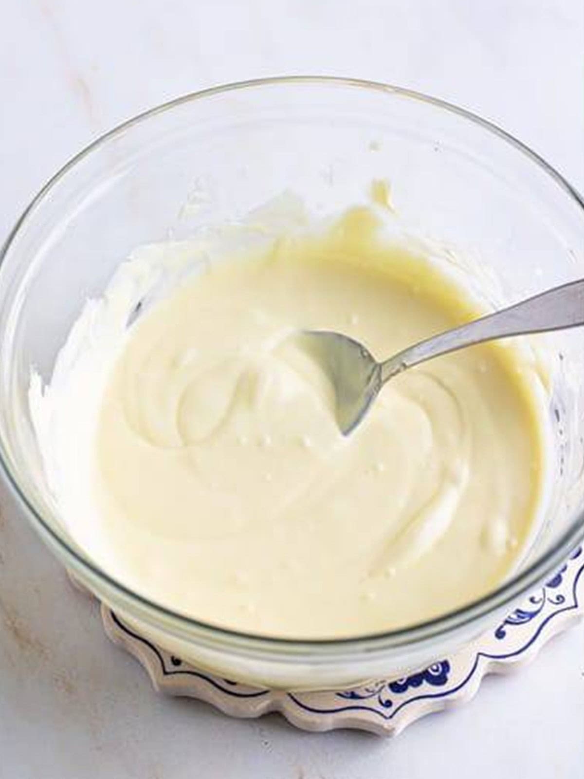 Melted white chocolate in a glass bowl for white chocolate truffles.