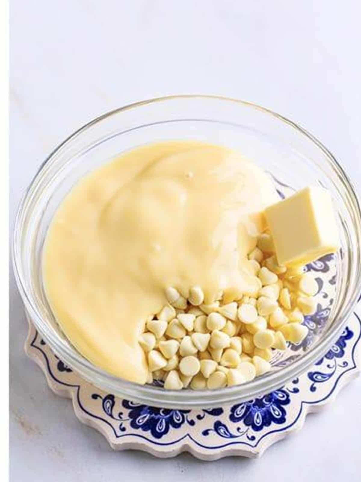 White chocolate chips, butter, and condensed milk in a bowl for truffle ganache.