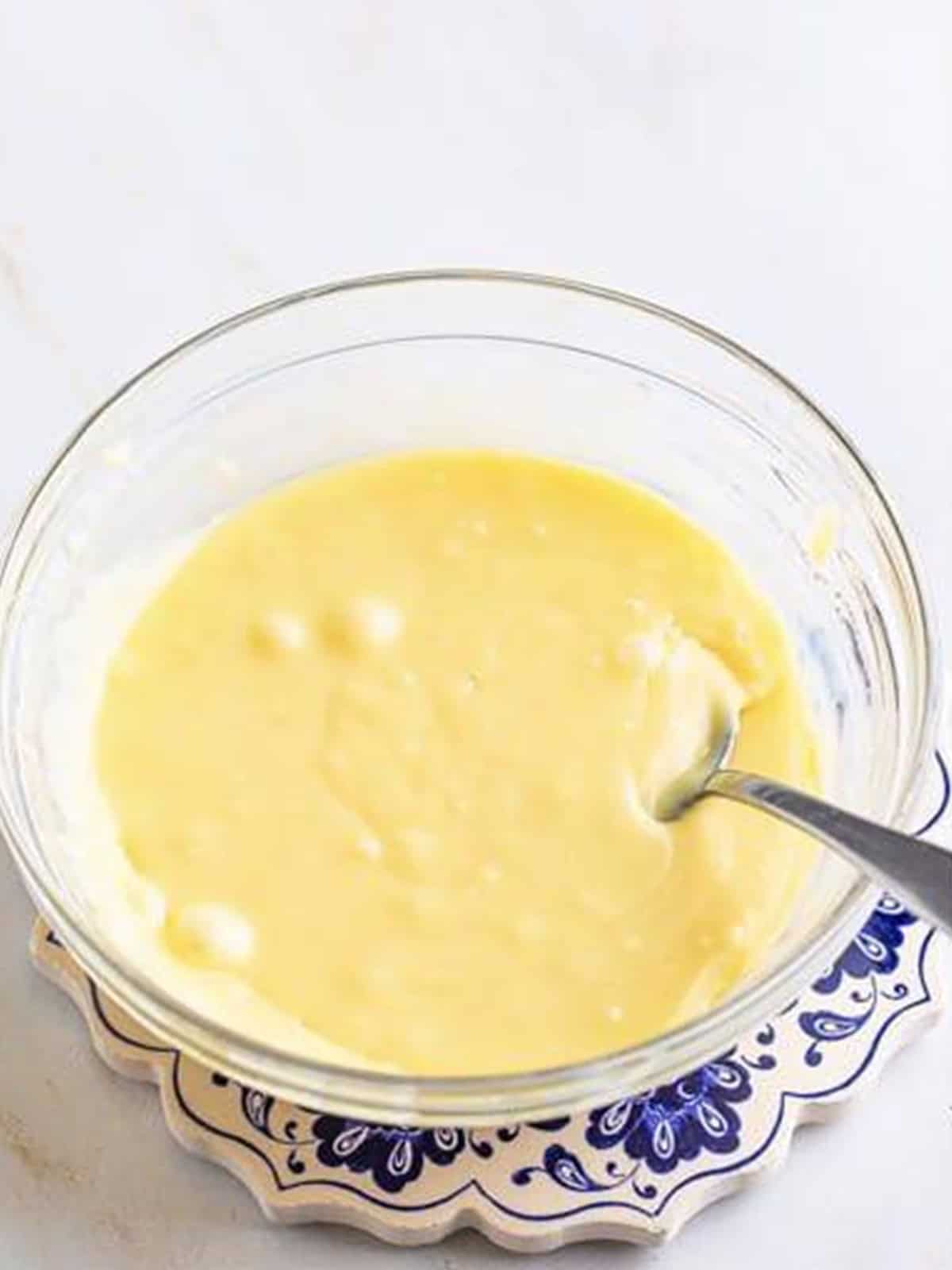 Smooth white chocolate ganache stirred in a bowl for white chocolate truffles.
