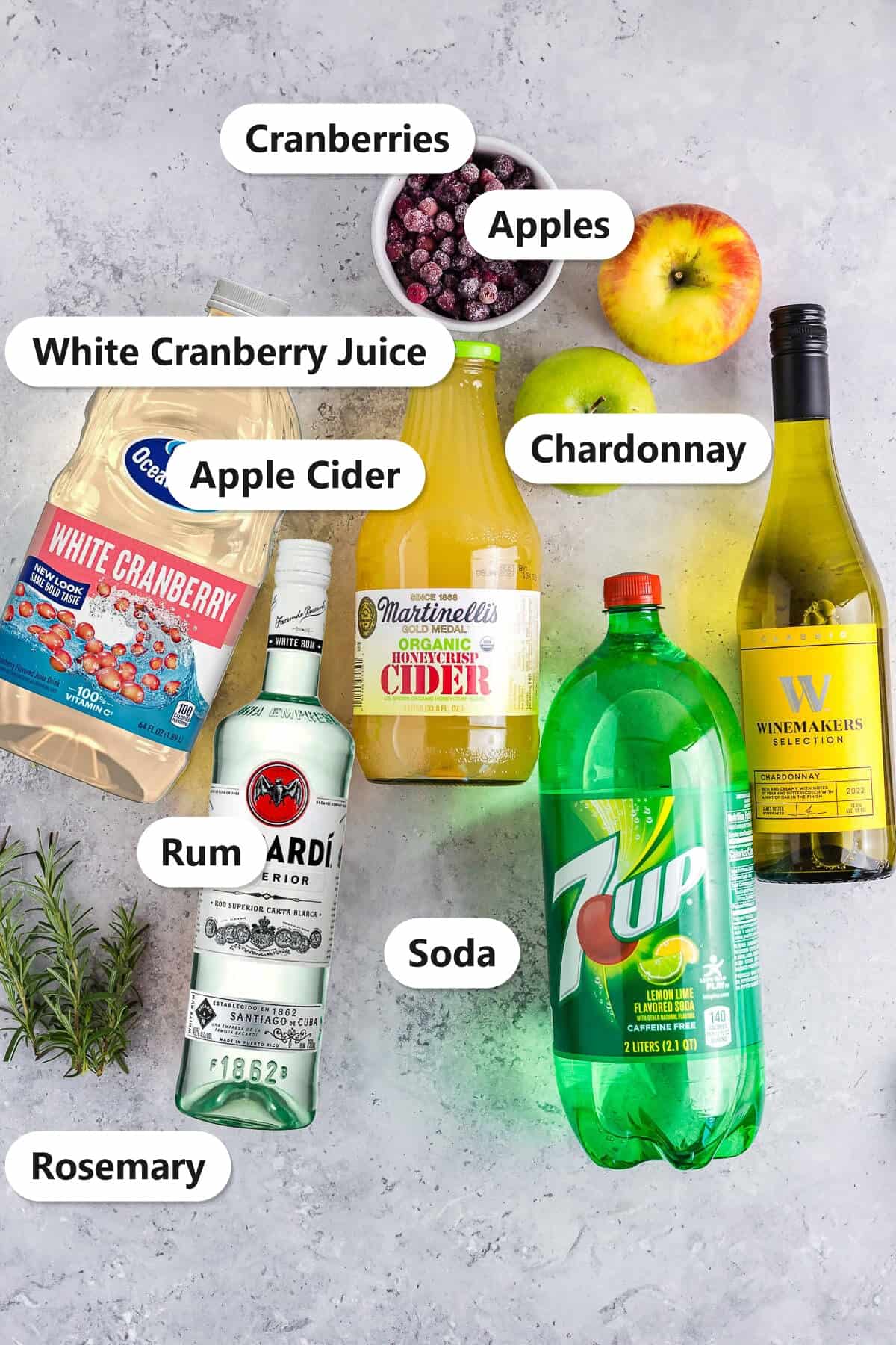 White wine sangria ingredients labeled including chardonnay, rum, apple cider, white cranberry juice, apples, cranberries, and soda.