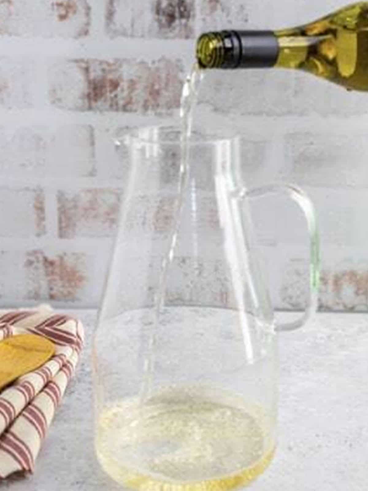 Pouring chardonnay into a pitcher for white wine sangria.