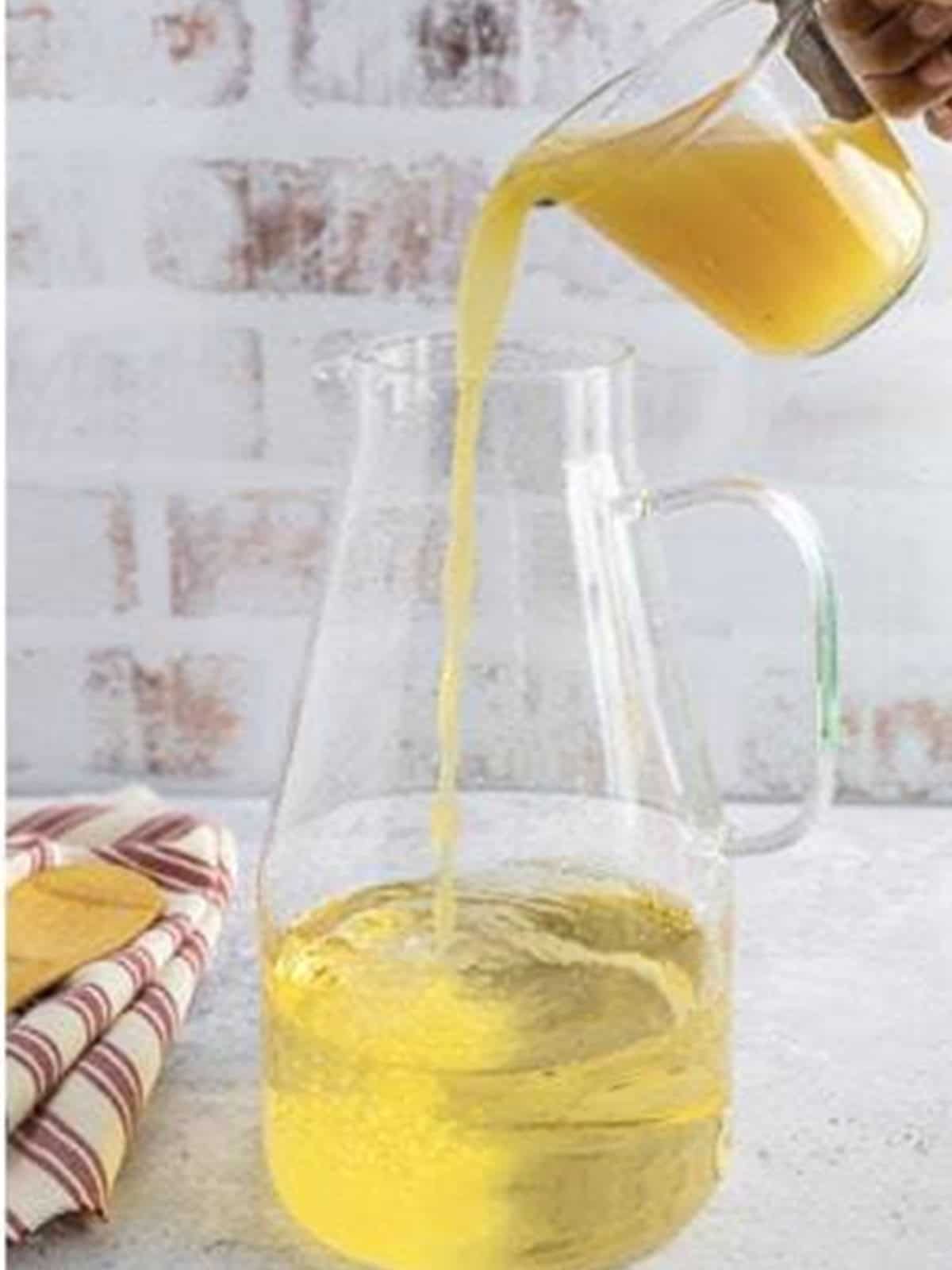 Pouring apple cider and cranberry juice into the white wine sangria.