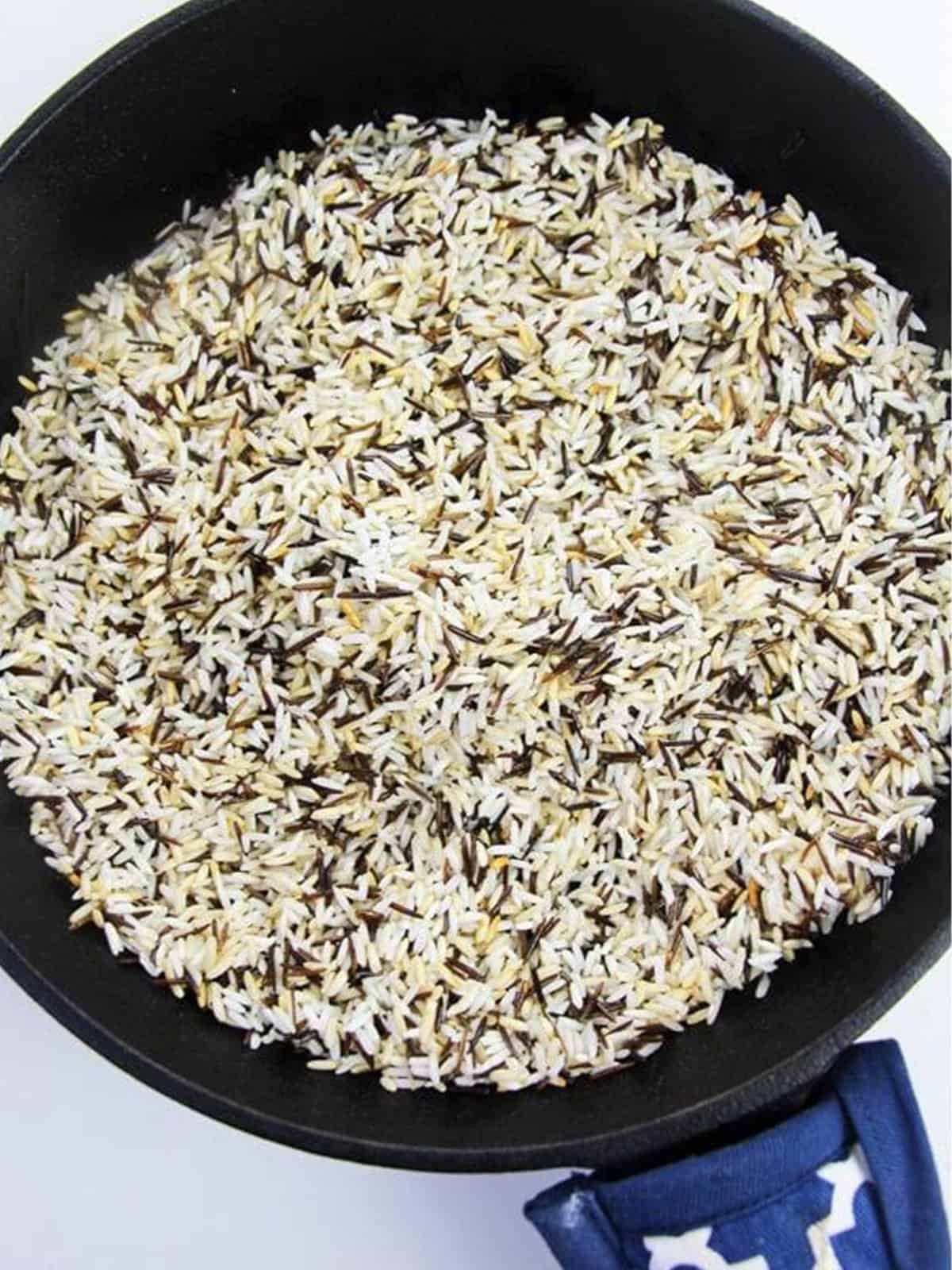 Wild rice blend toasting in a skillet for wild rice salad.
