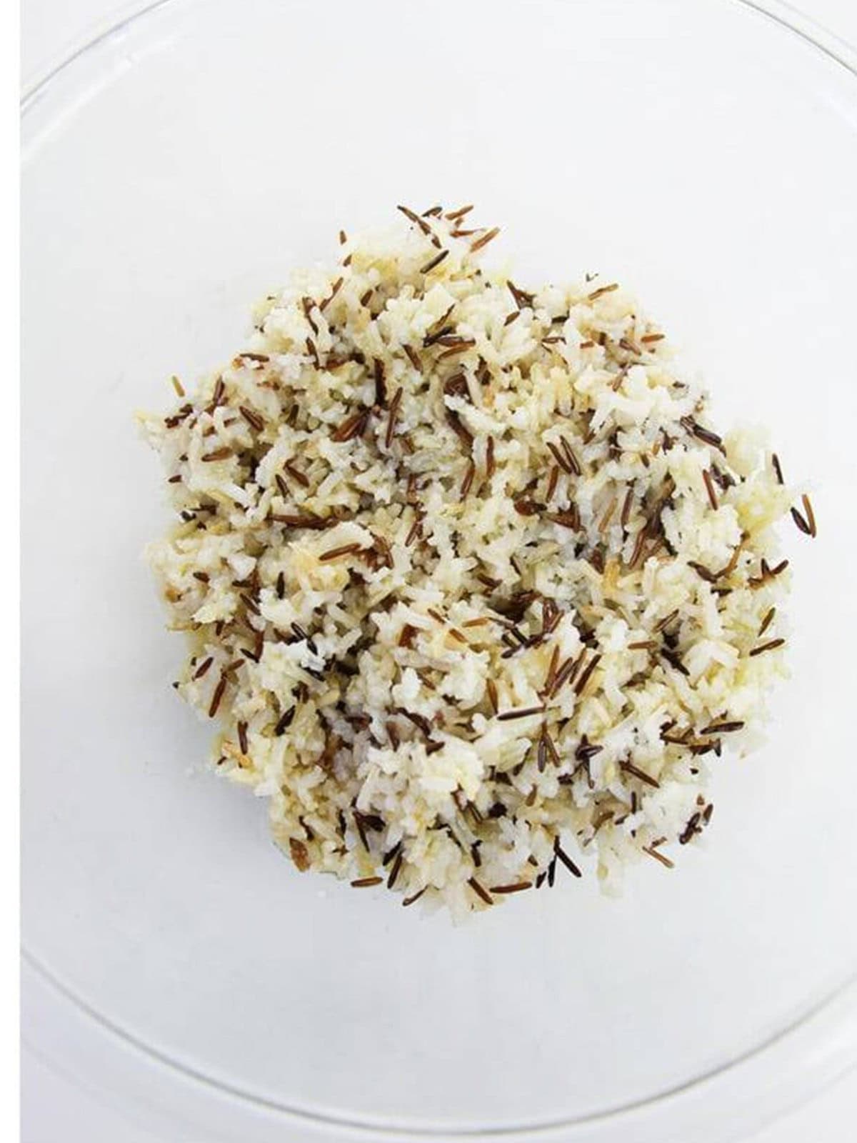 Cooked and cooled wild rice blend in a glass bowl.