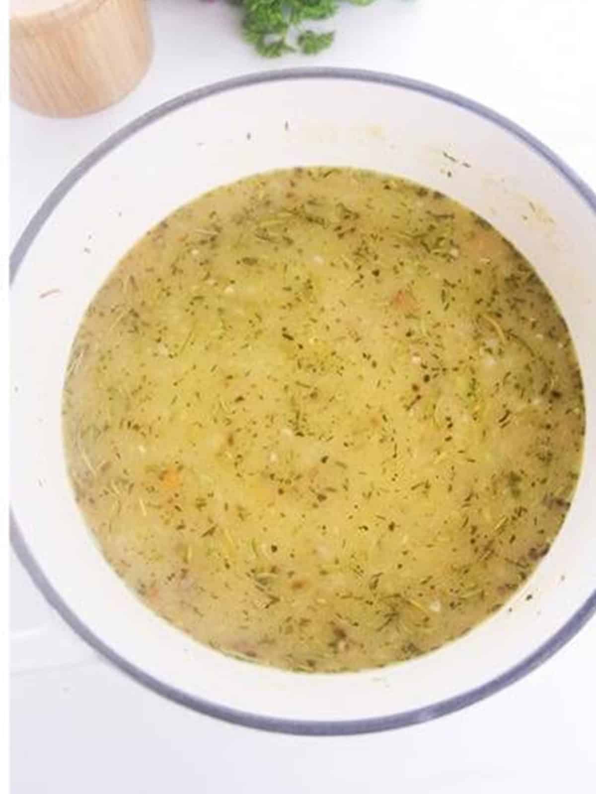 Chicken broth poured into the pot with the vegetables and roux.