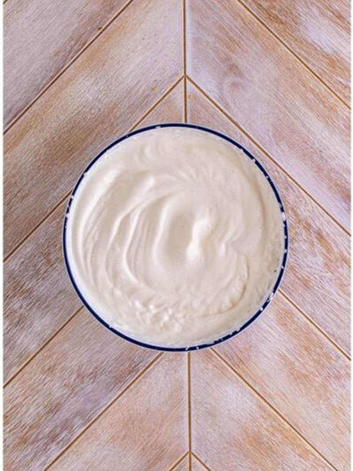 Cold evaporated milk whipped to stiff peaks in a white bowl for woolworth cheesecake recipe.