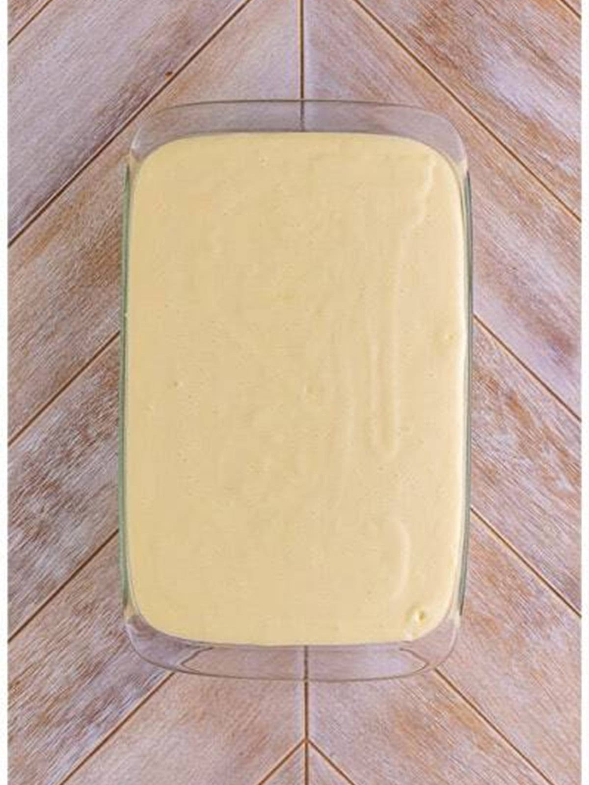 Lemon cheesecake filling poured over the graham cracker crust in a 9x13 dish for woolworth cheesecake recipe.