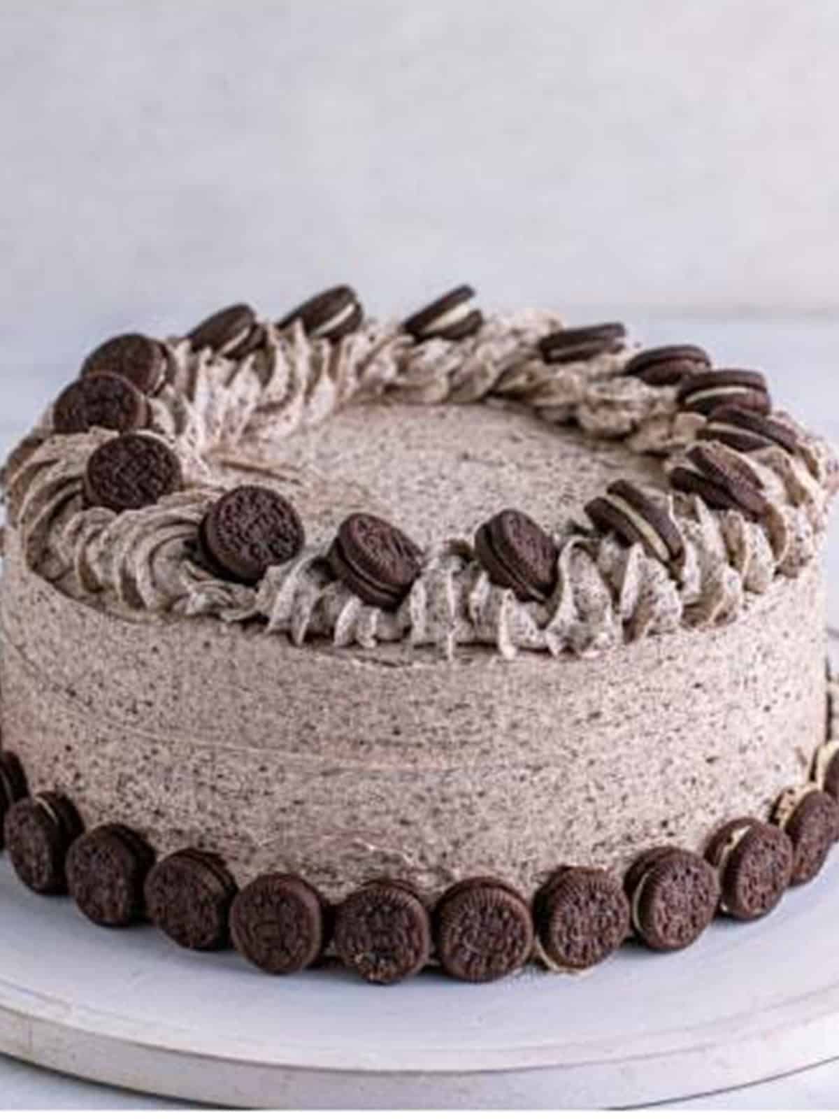 Finished zebra cake frosted with cookies and cream frosting and topped with mini Oreos.