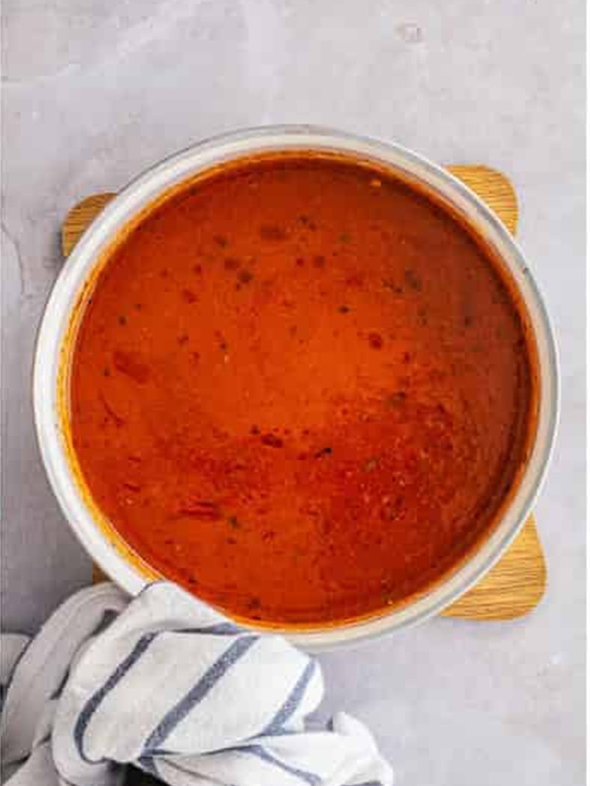 Red enchilada sauce in a pot for zucchini boats.