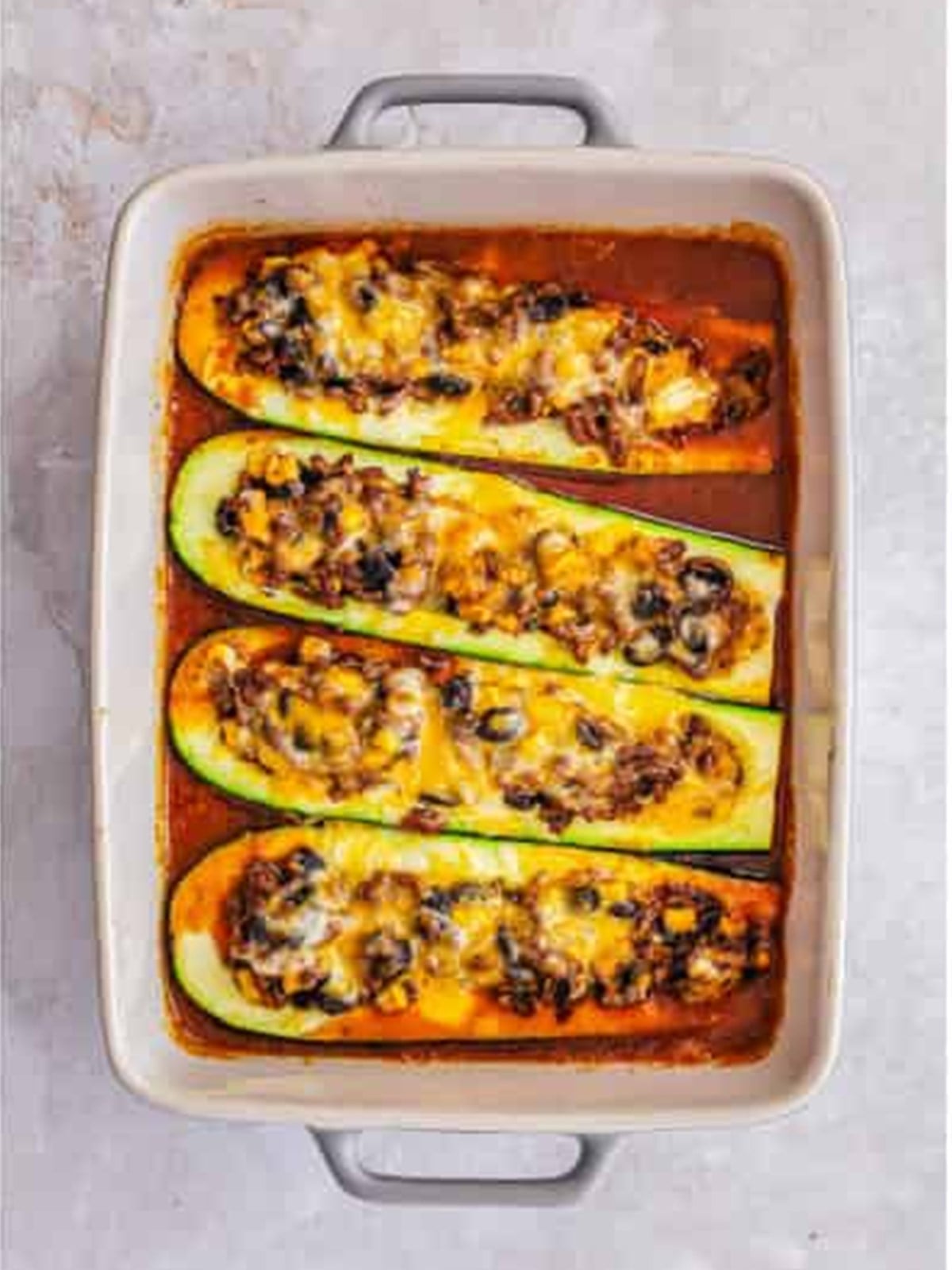 Baked enchilada zucchini boats topped with melted cheese.