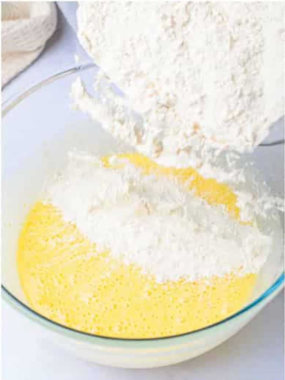 Dry ingredients being folded into the wet zucchini bread batter.