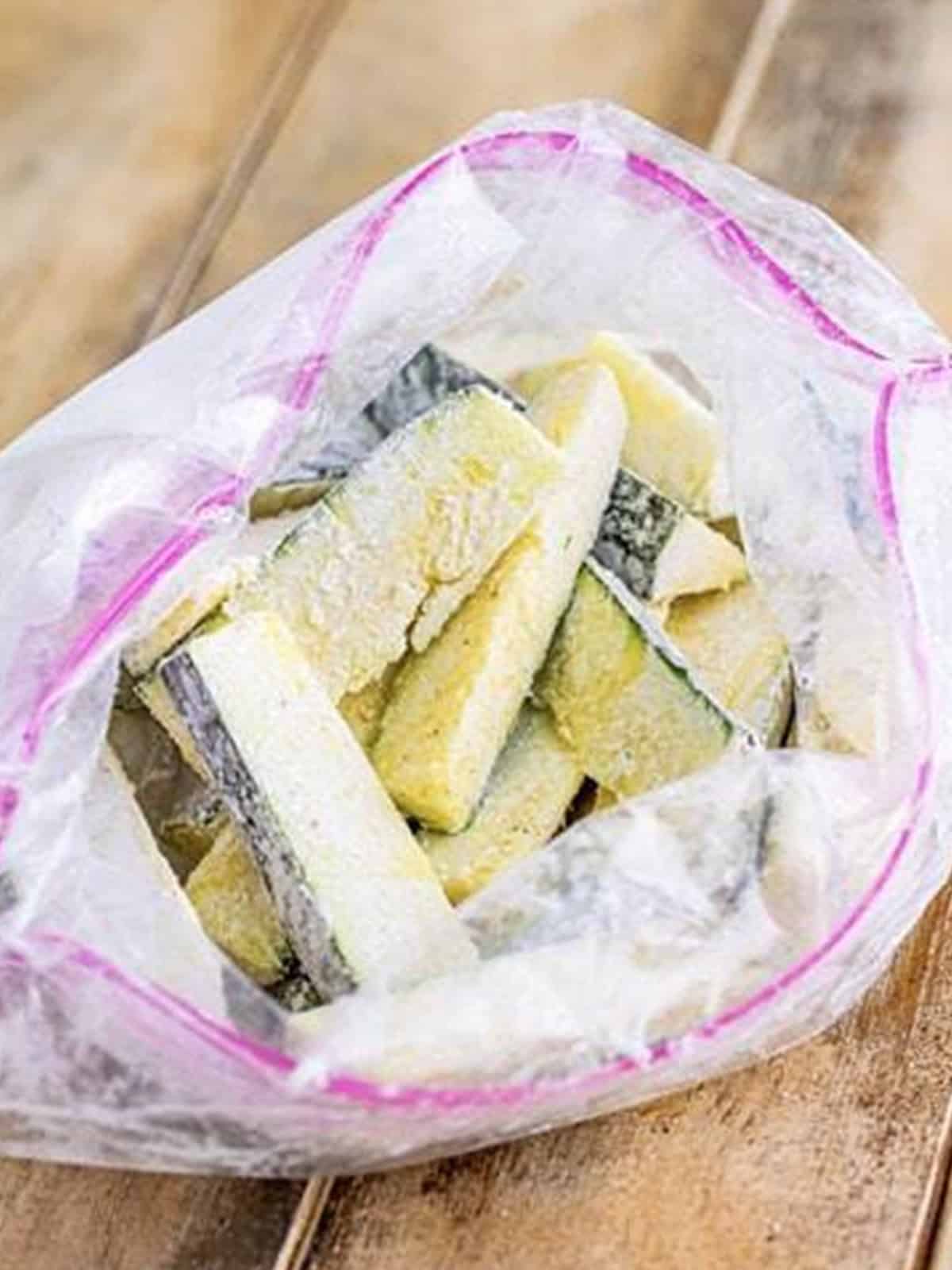 Zucchini sticks tossed with cornstarch and seasonings in a zip top bag.