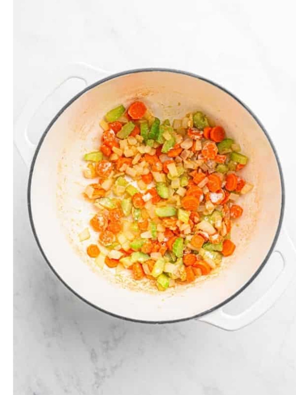 Diced carrots, celery, and onion softening in a pot for Zuppa Toscana.