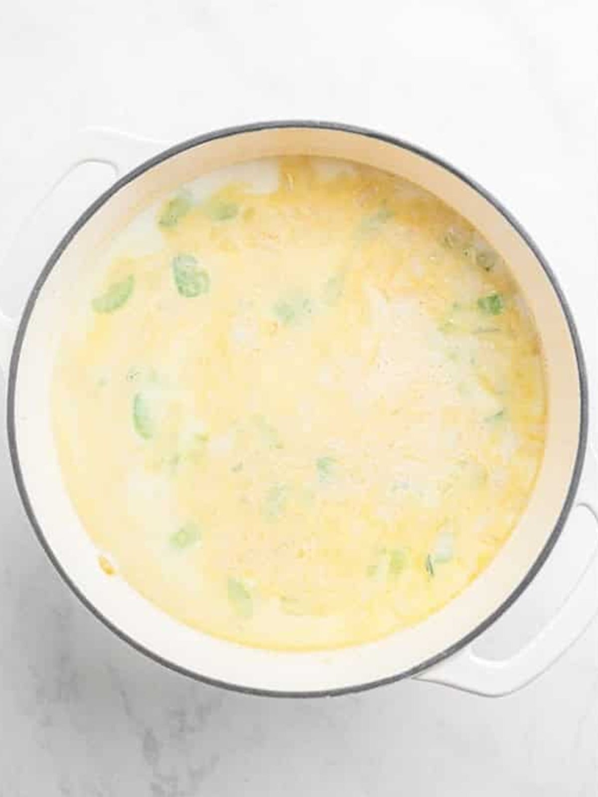 Creamy broth simmering with golden potatoes for Zuppa Toscana.