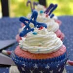 4th of July cupcake in a blue star liner topped with white funfetti frosting and a blue candy star.