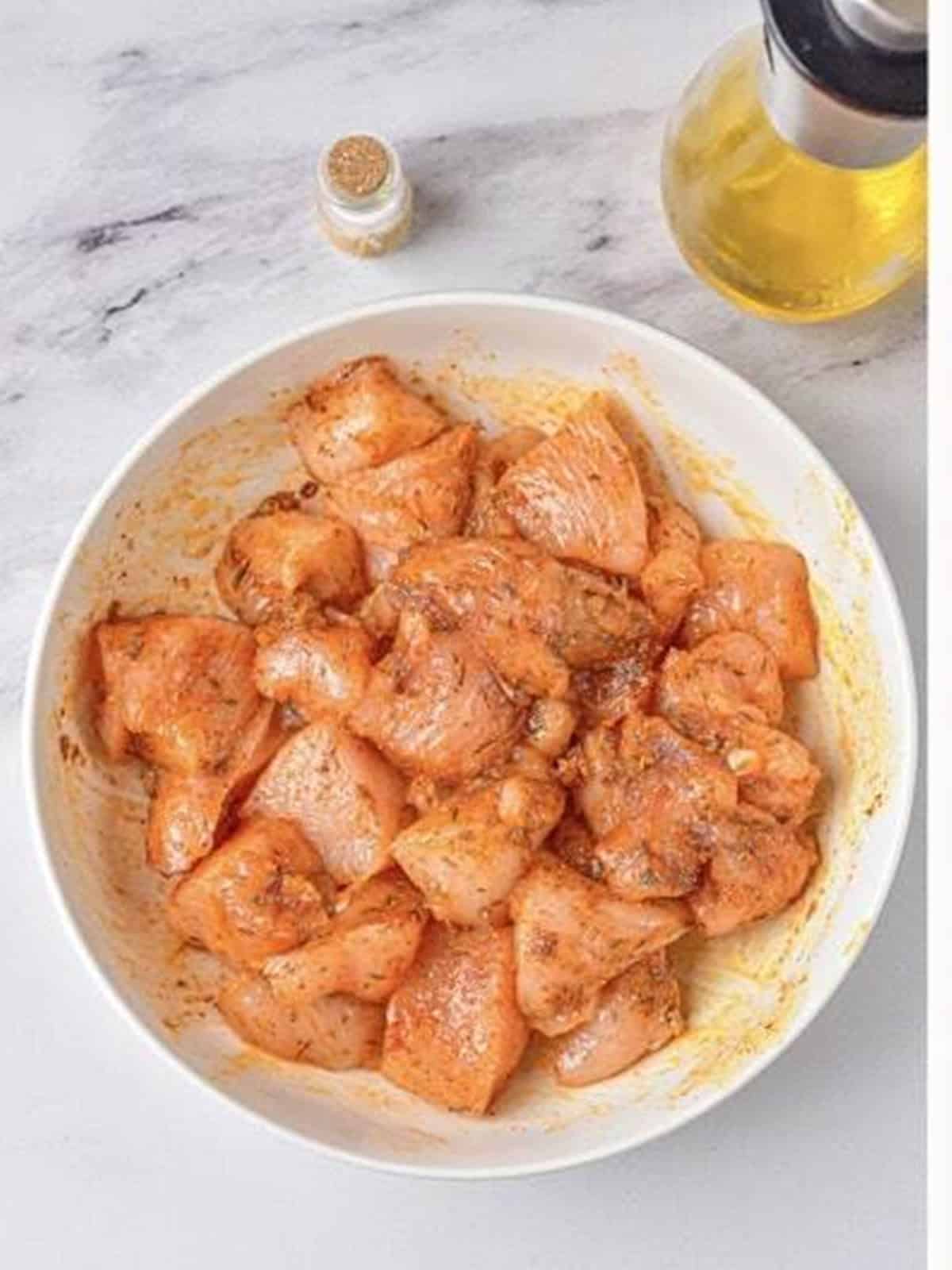 Diced chicken tossed with olive oil and seasonings until evenly coated.