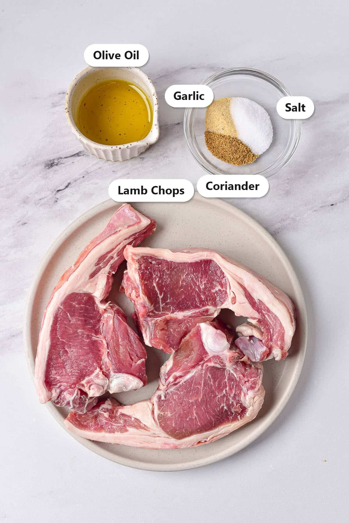 Labeled ingredients for air fryer lamb chops including lamb chops, olive oil, garlic, salt, and coriander.